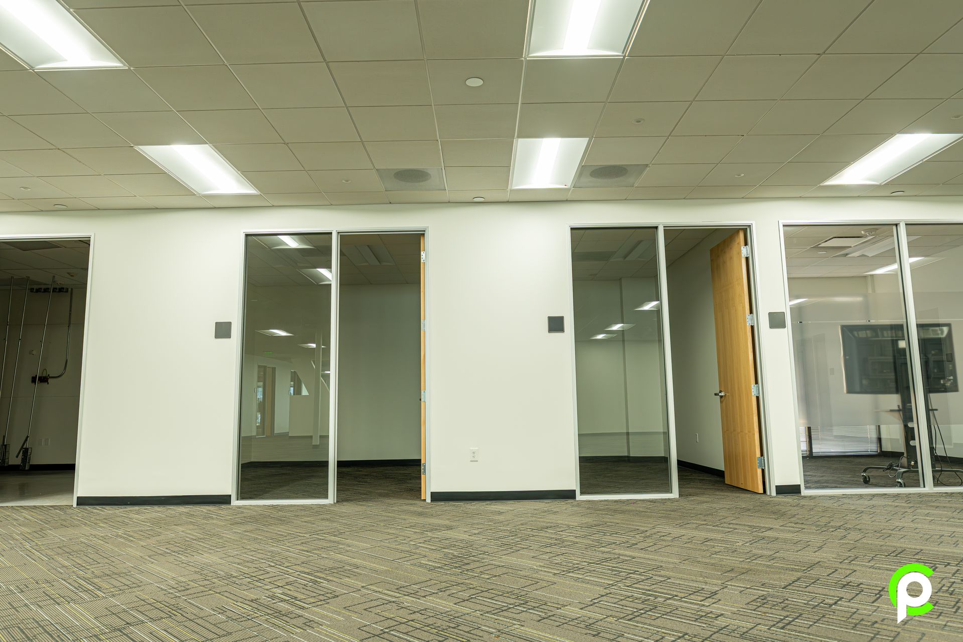A large empty office with a lot of windows and doors.