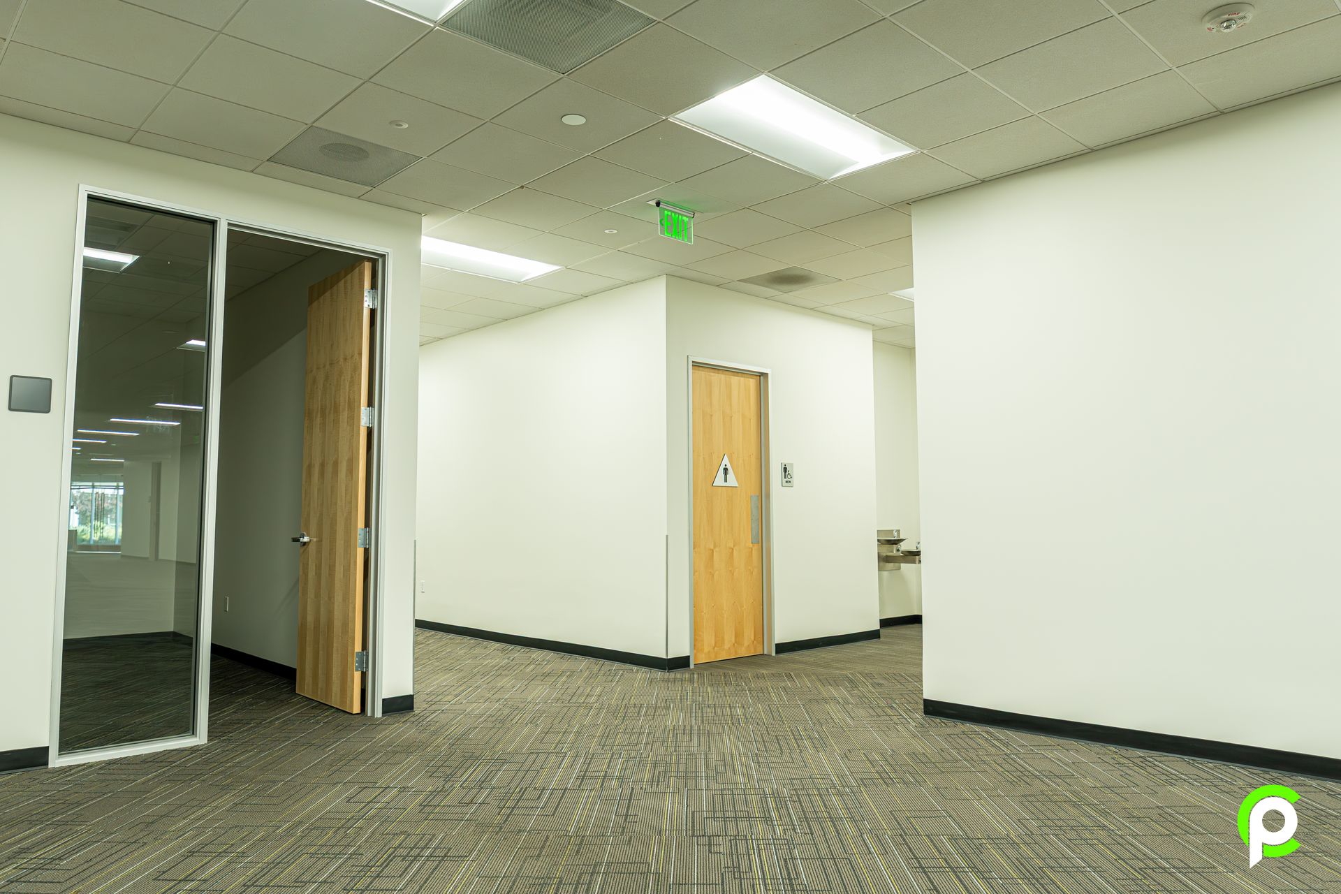 An empty office building with a carpeted floor and white walls.