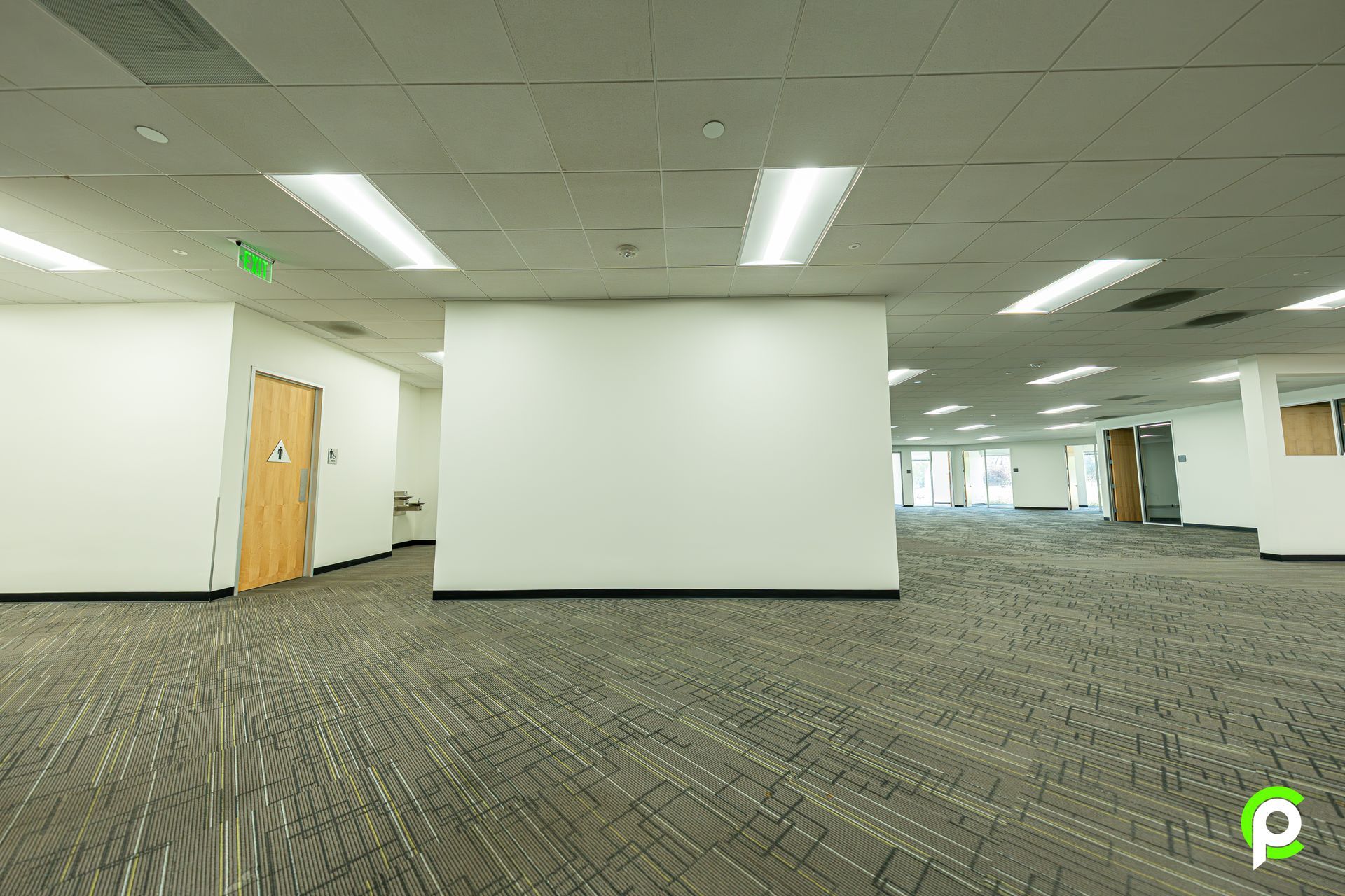 A large empty office building with a carpeted floor and white walls.