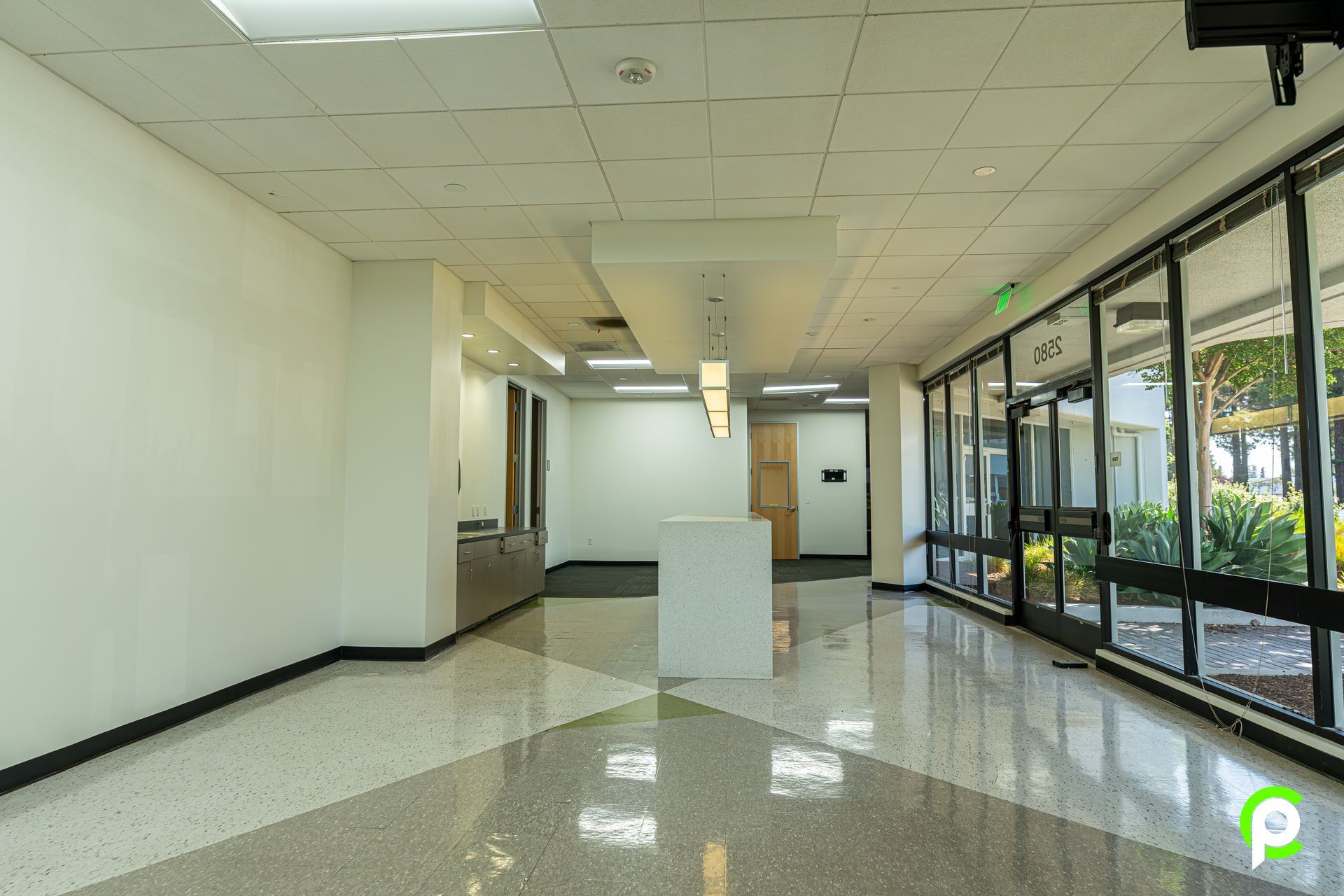 An empty hallway with a lot of windows and a counter.