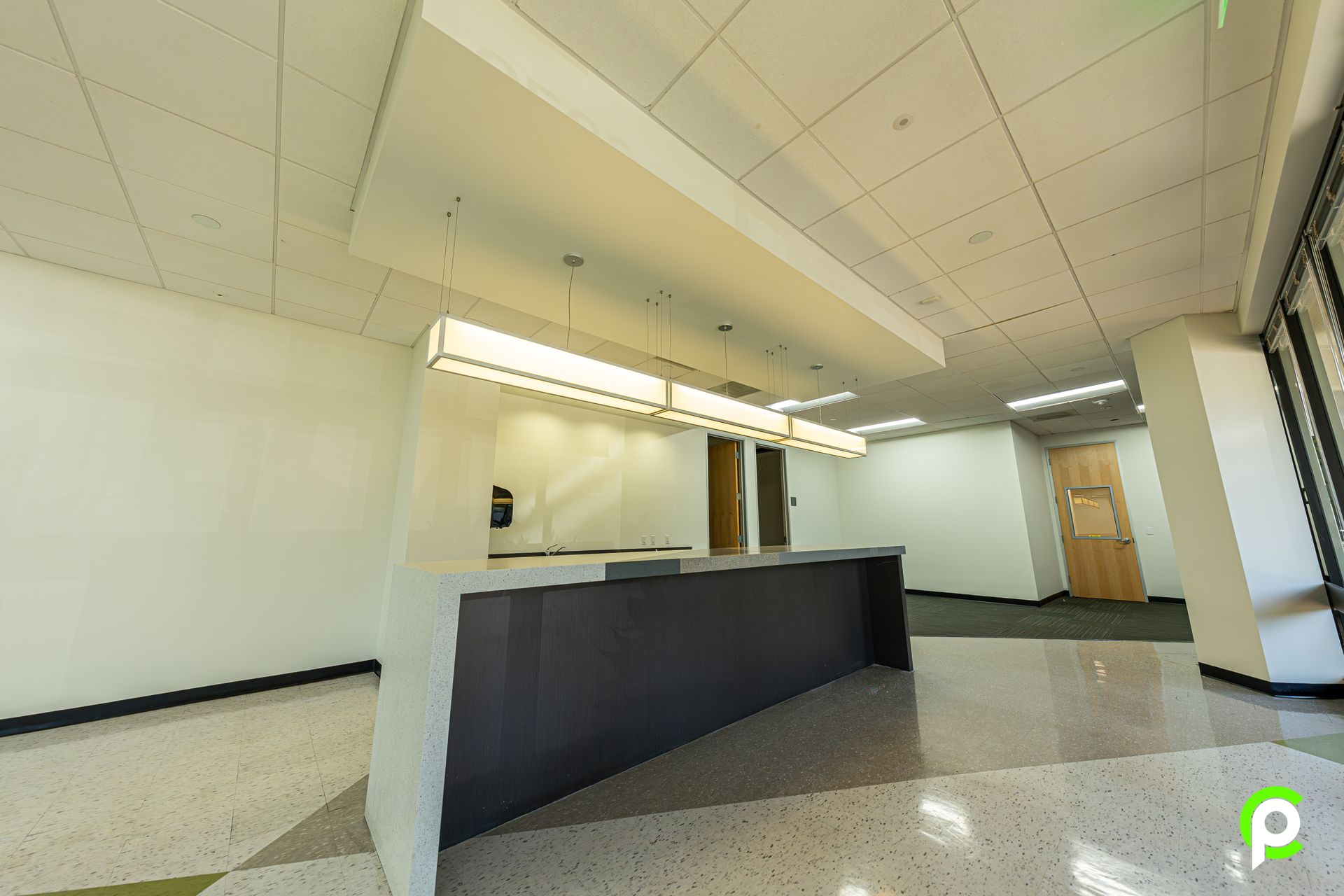 A large empty room with a counter in the middle of it.