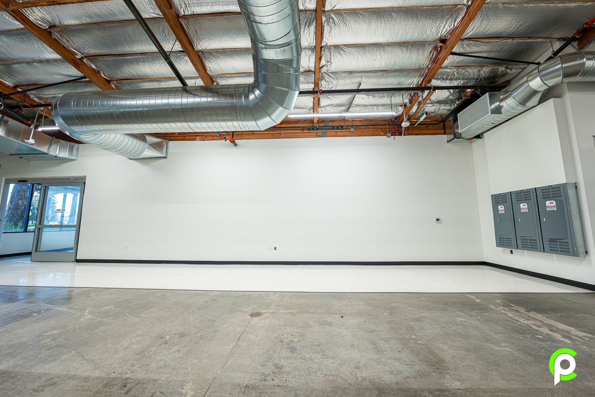 An empty room with a ceiling fan and a door.