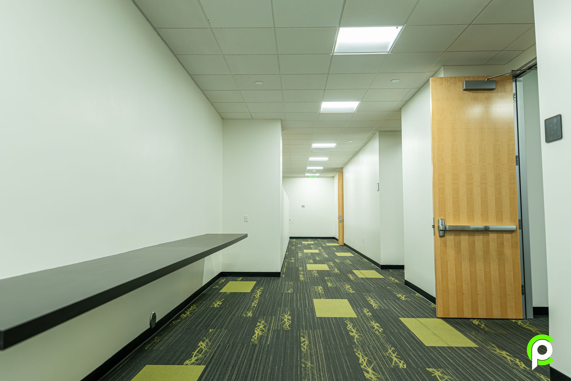An empty hallway with a wooden door and a wooden table.