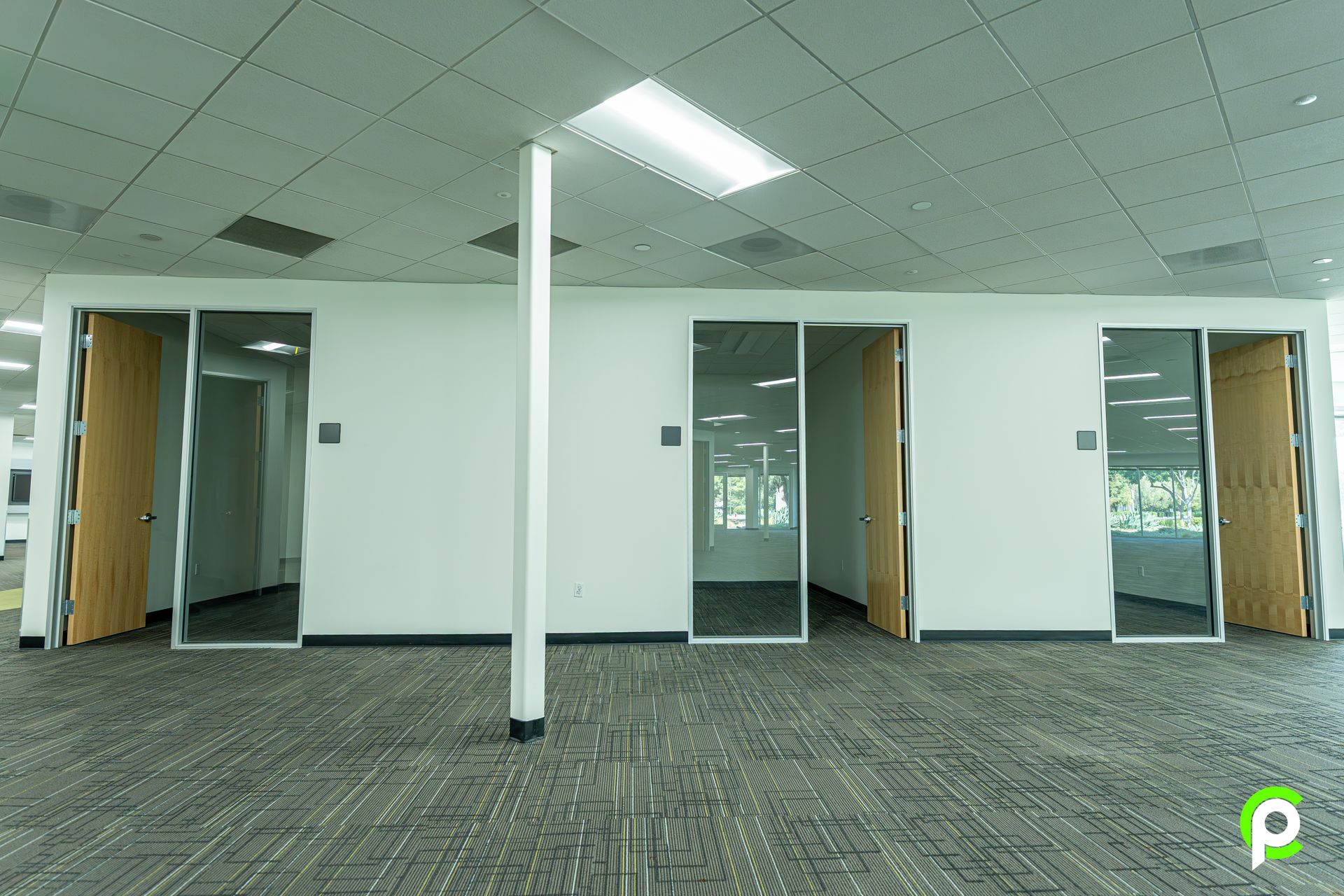 A large empty room with a carpeted floor and white walls.