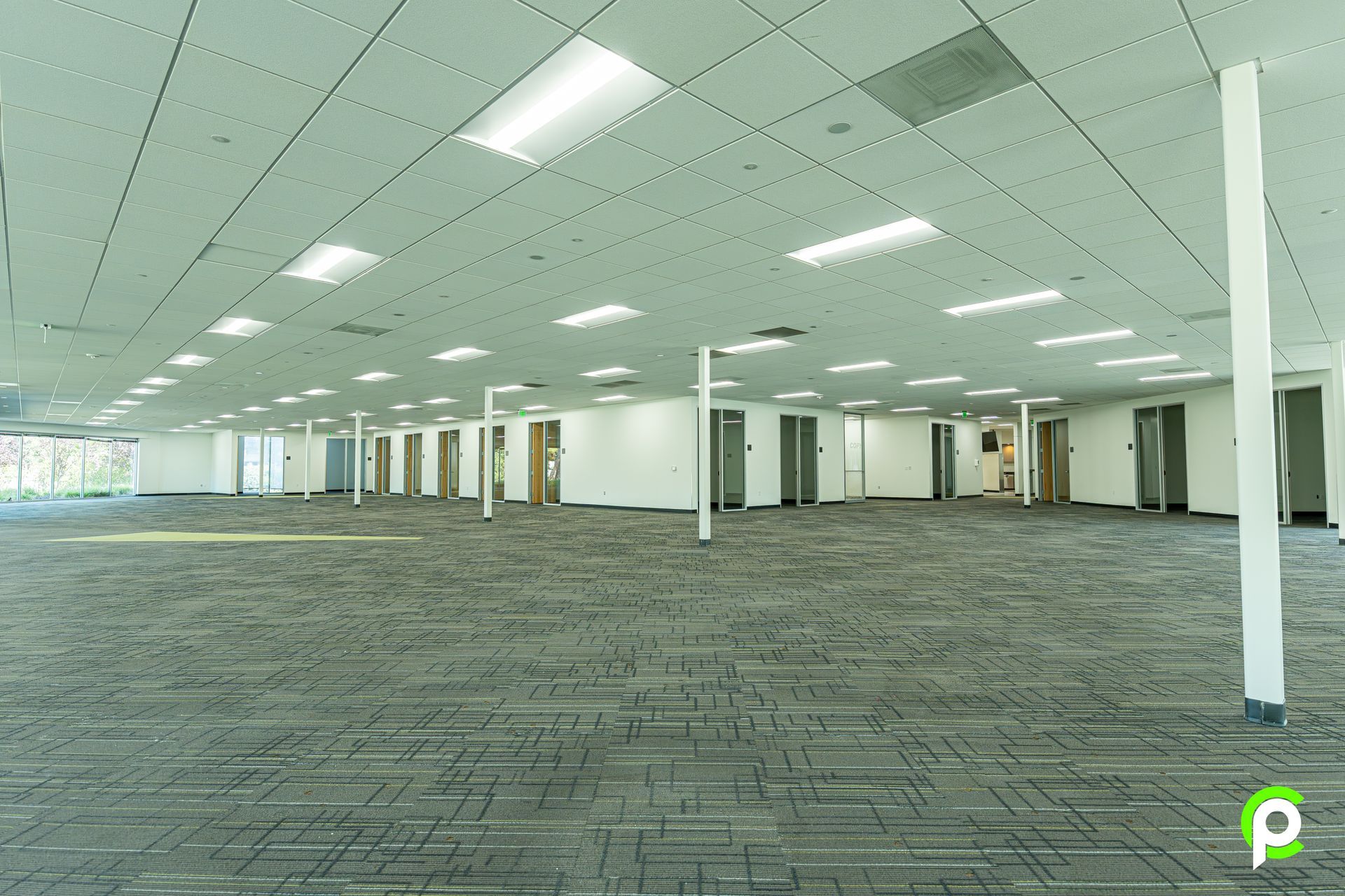 A large empty office building with a carpeted floor.