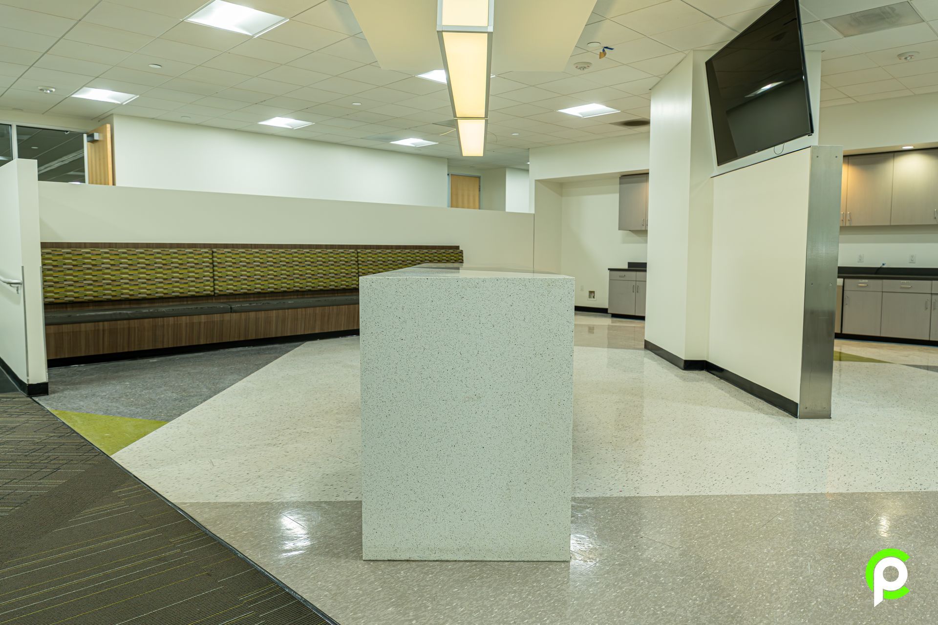 A large empty room with a counter in the middle of it.