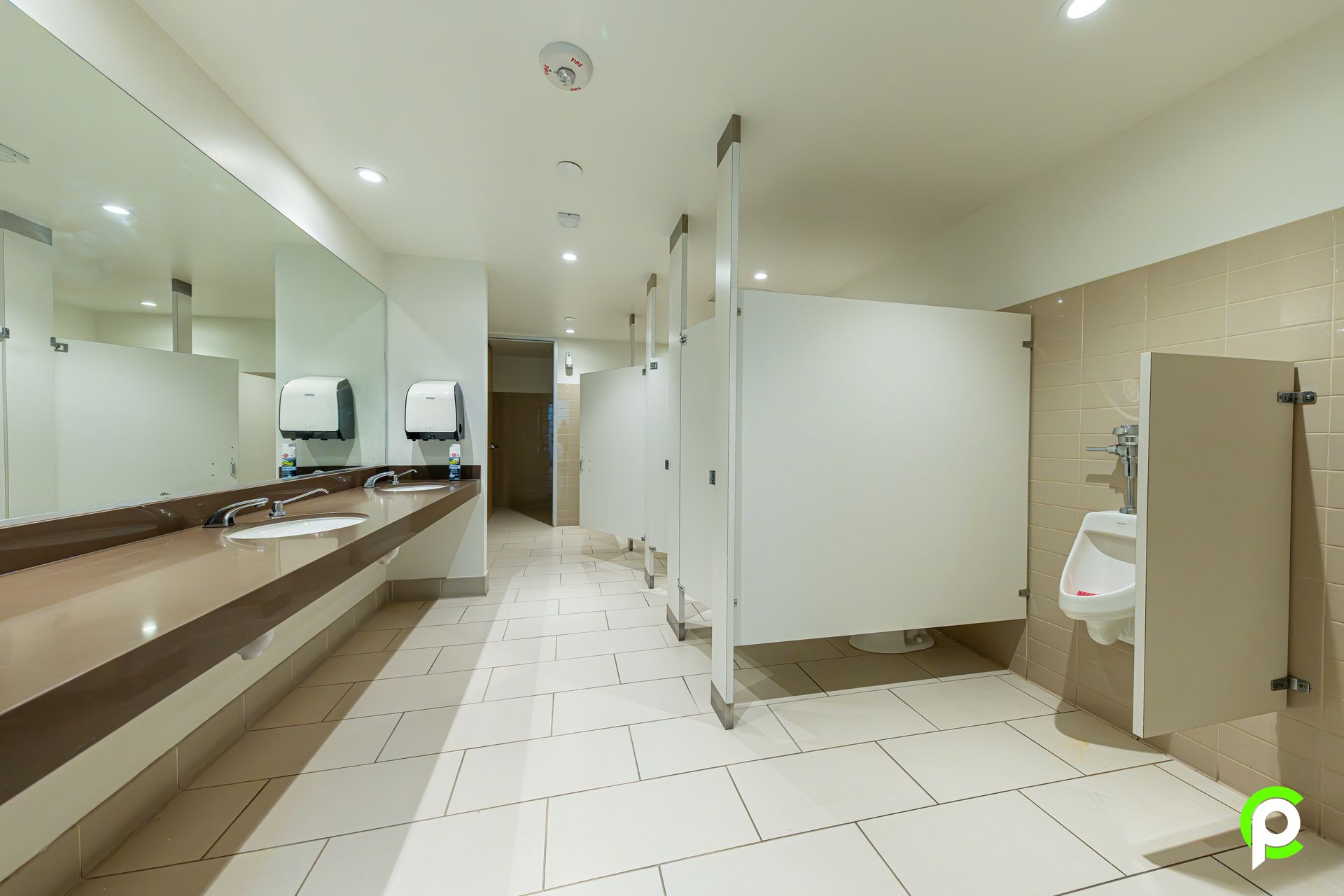 A public restroom with a urinal , sinks and mirrors.