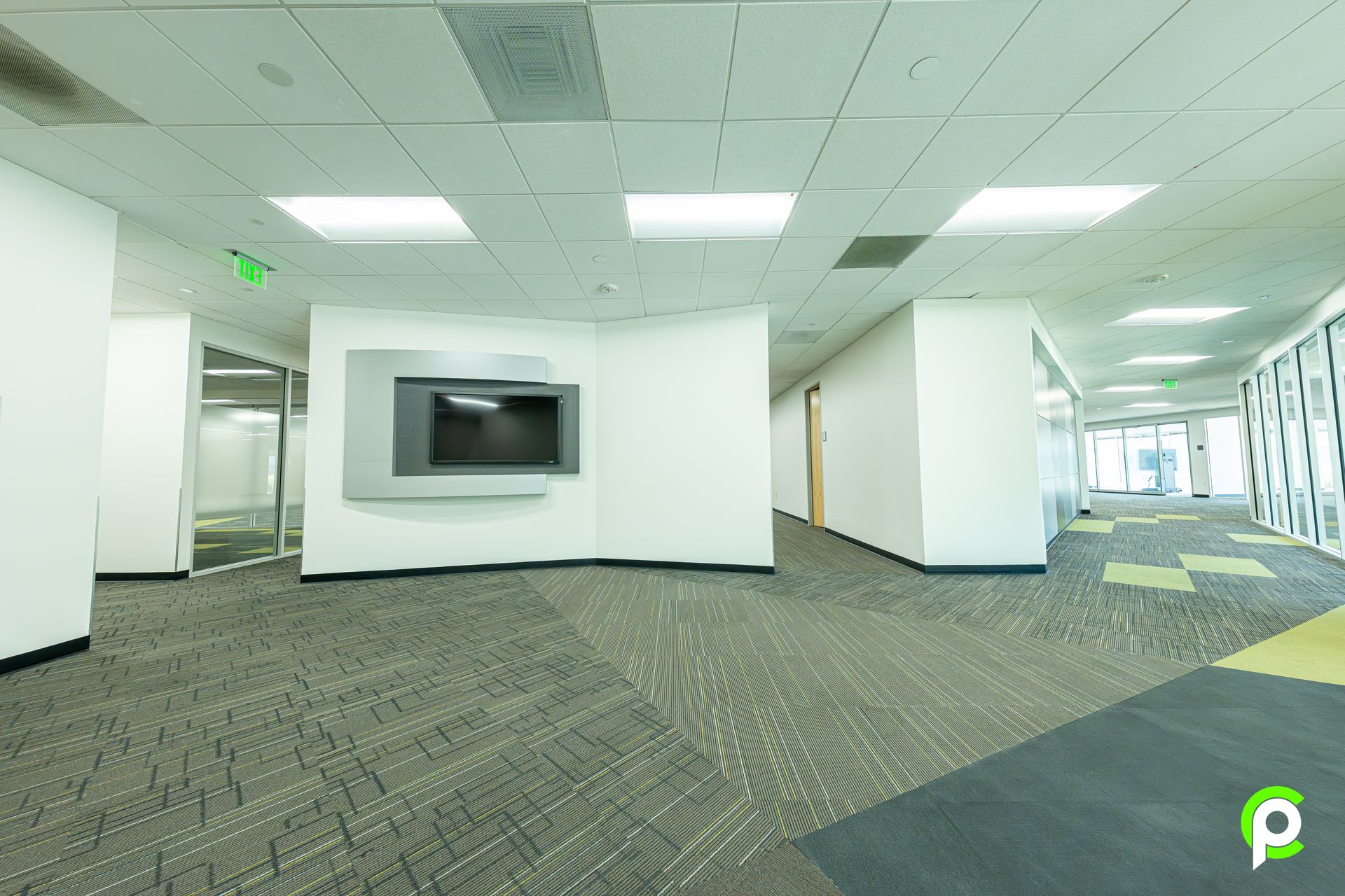 An empty hallway with a flat screen tv on the wall.