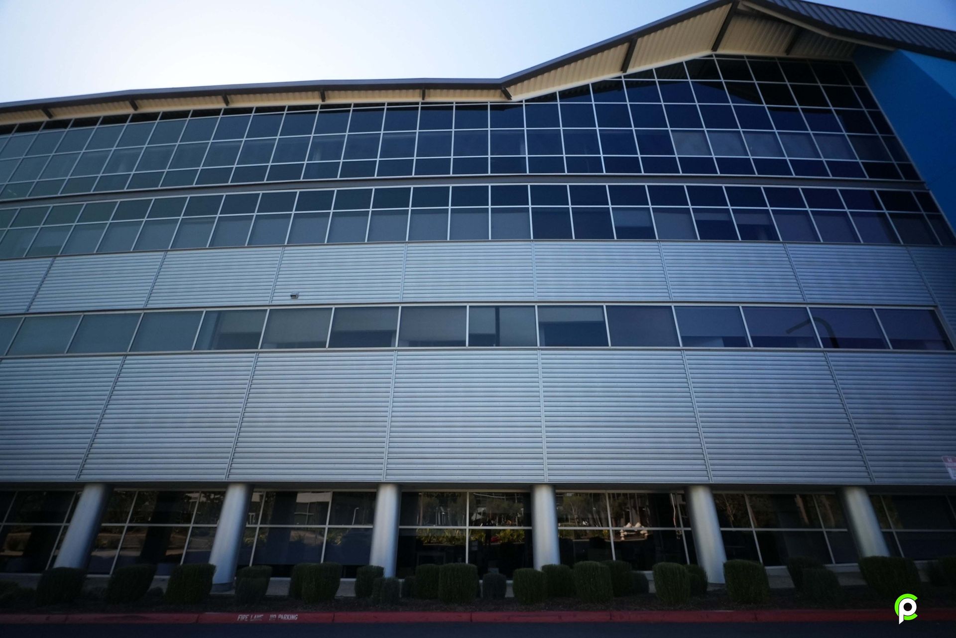 A large building with a lot of windows and a blue roof