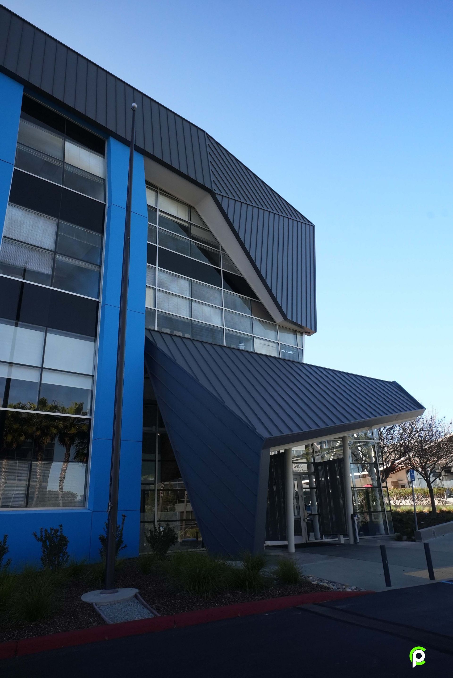 A large blue building with a black roof