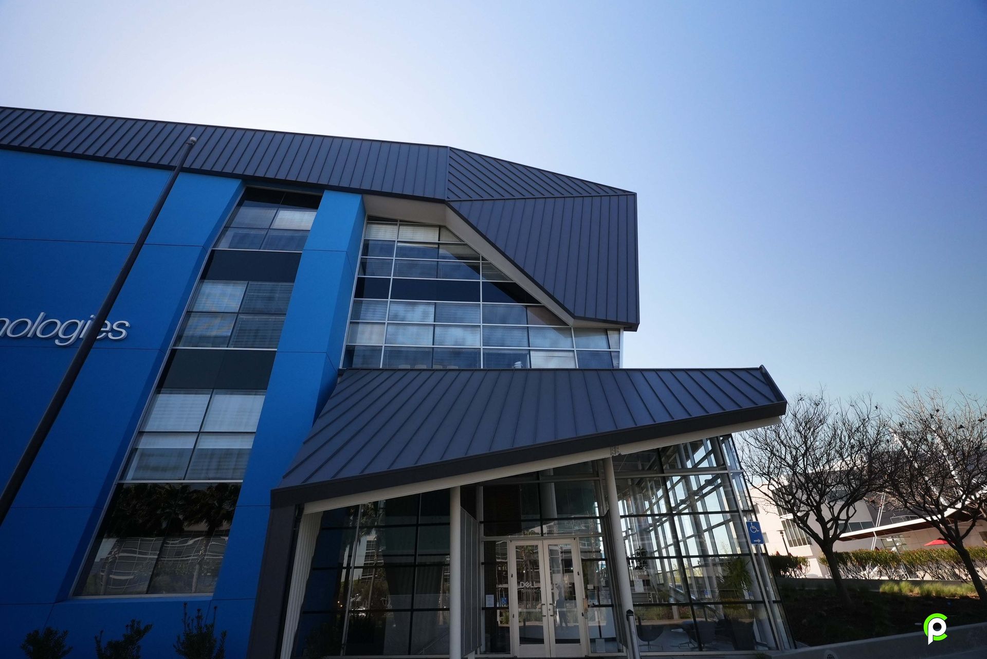 A blue building with a black roof and a door
