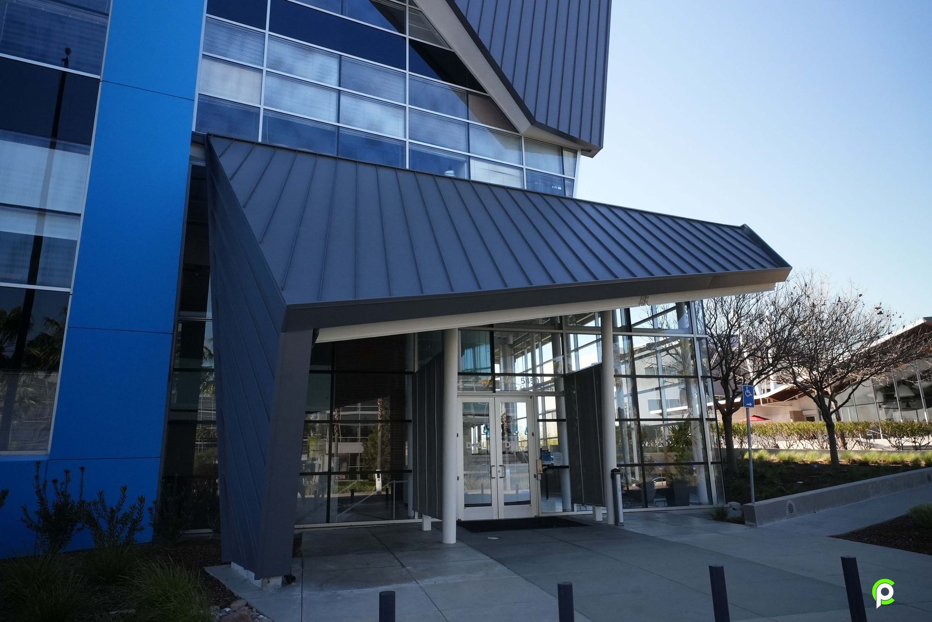 A blue building with a black roof and a white door