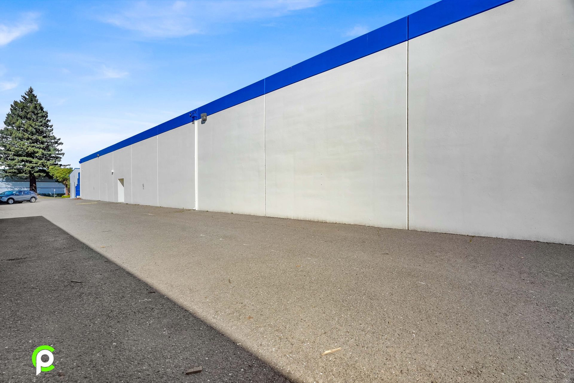 A large white building with a blue stripe on the side