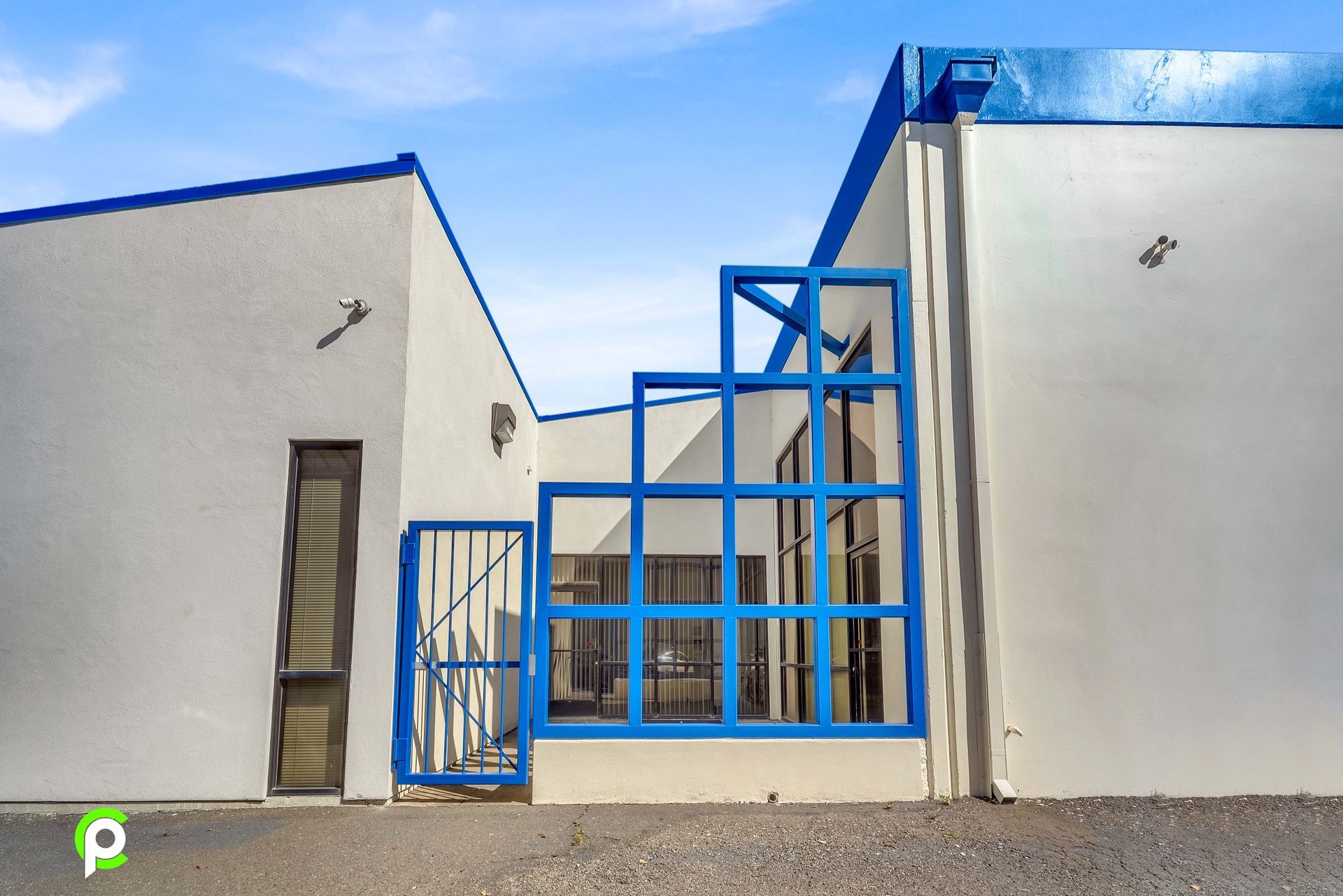 A white building with a blue gate and stairs