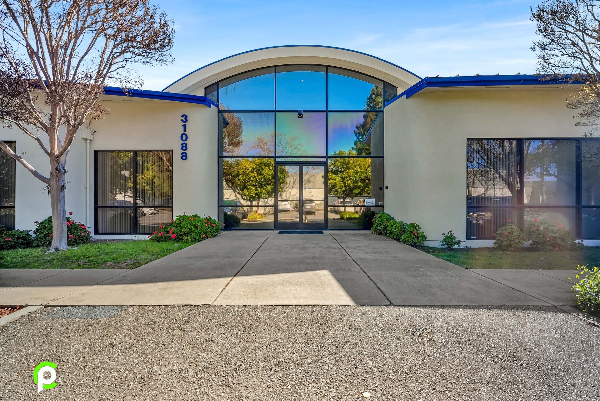 A white building with a blue roof and a large window