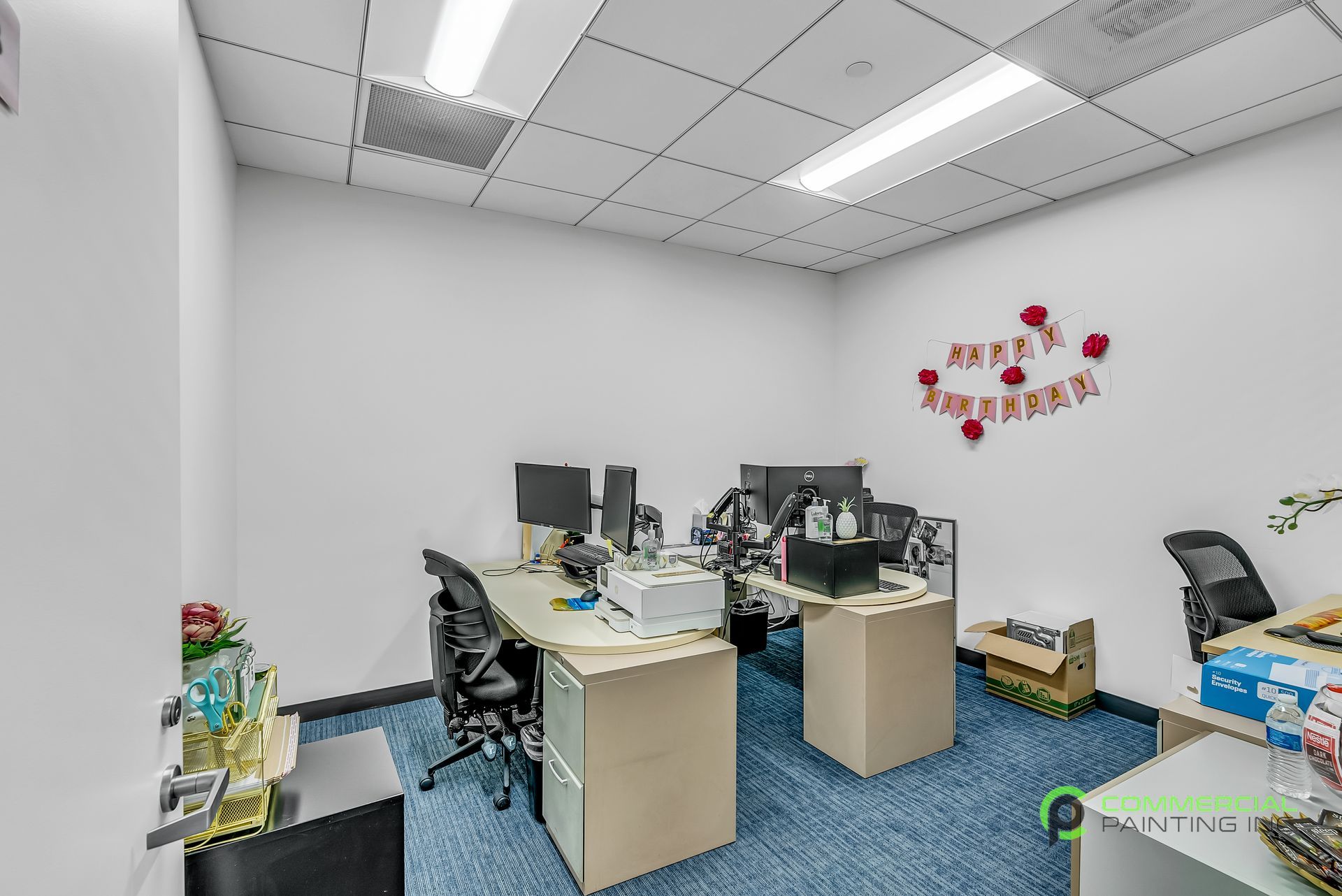 A small office with a lot of desks and chairs.