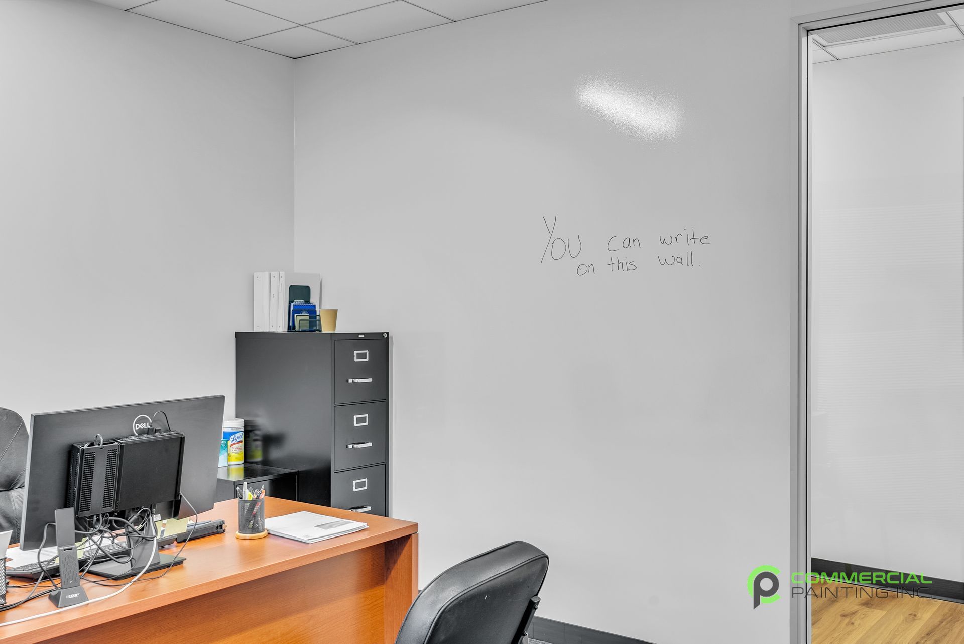 An office with a white board on the wall and a desk and chair