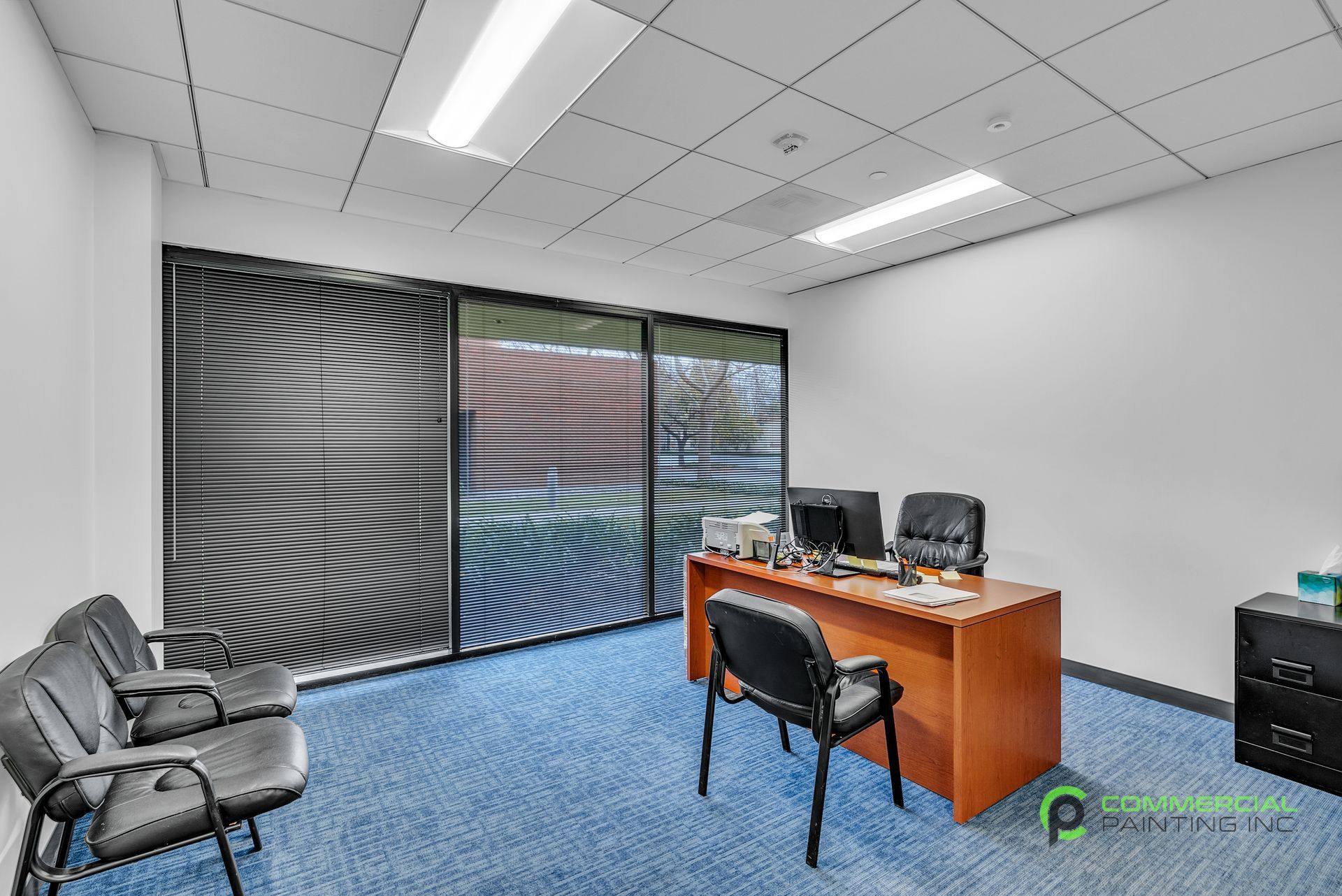 A waiting room with a desk and chairs in it.