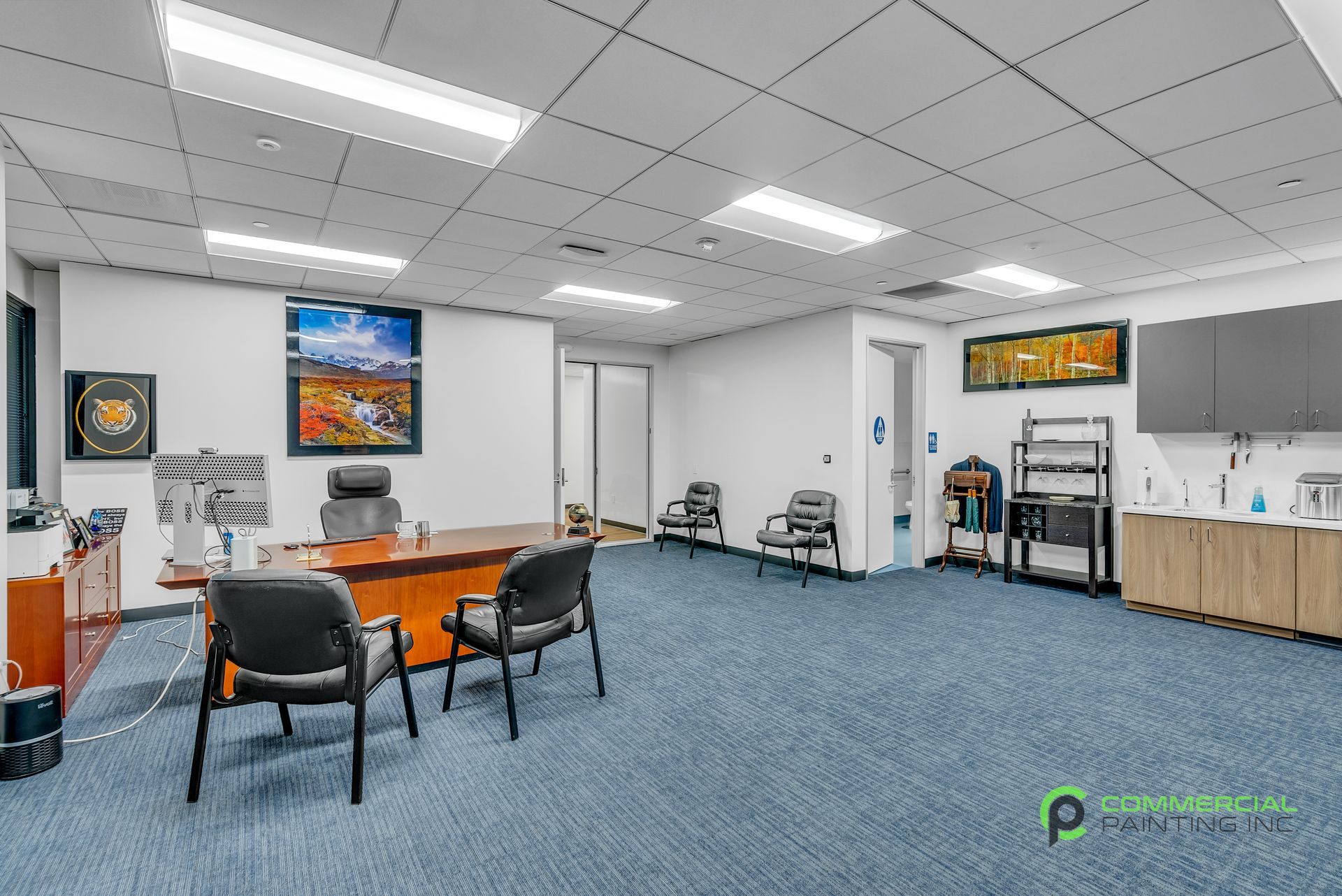 A large room with a desk and chairs in it.