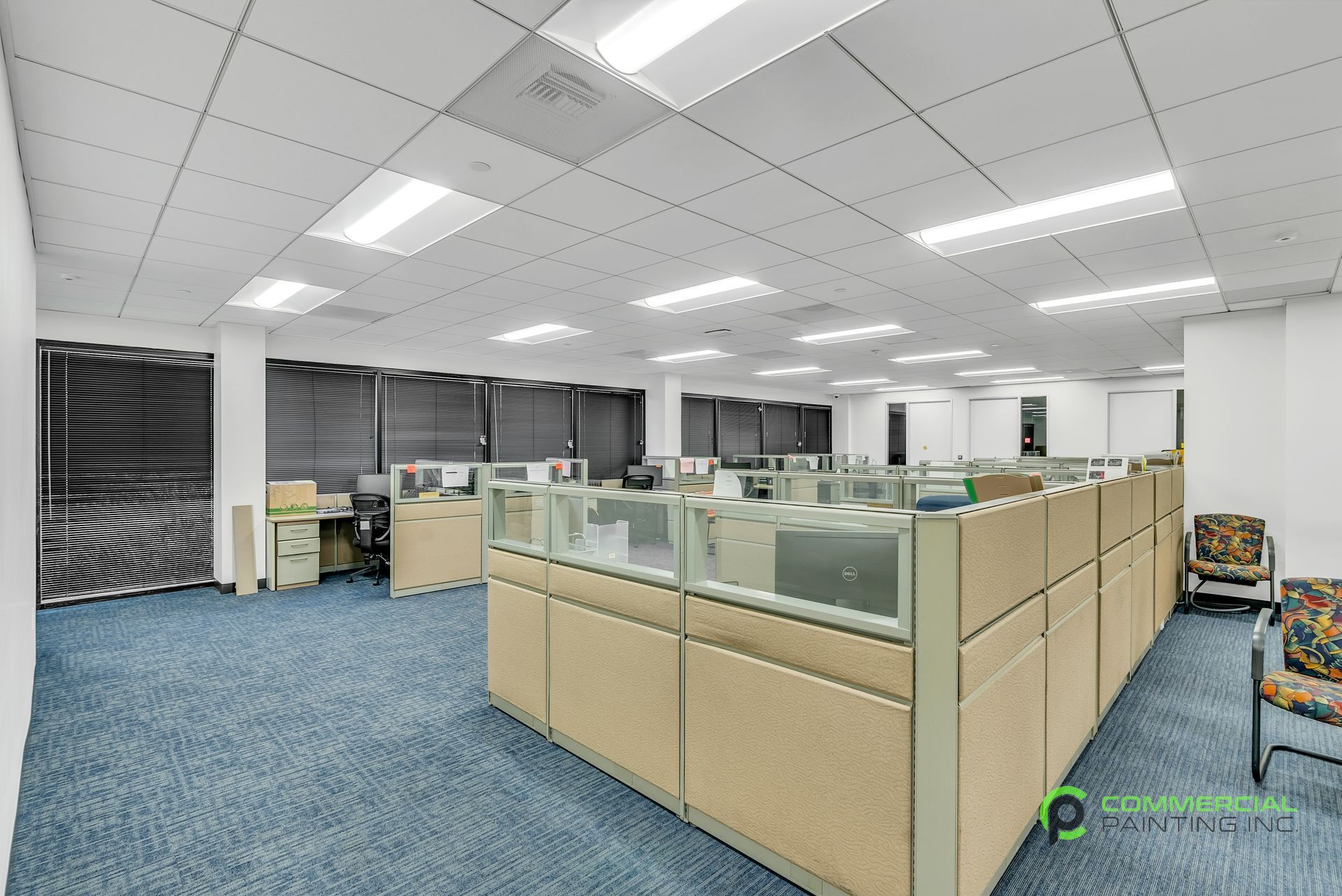 A large office with a lot of cubicles and chairs.