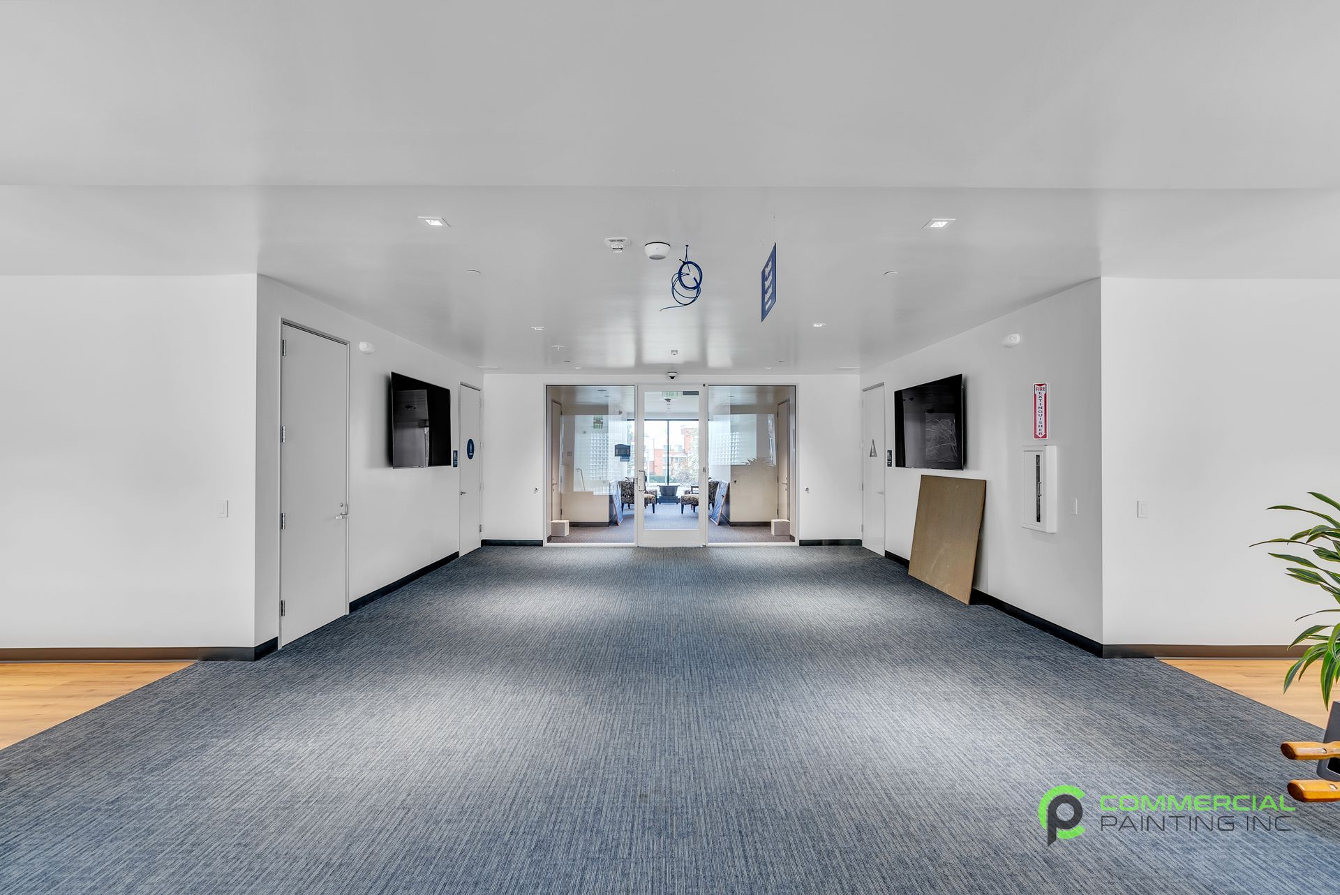 An empty hallway with a blue carpet and white walls.