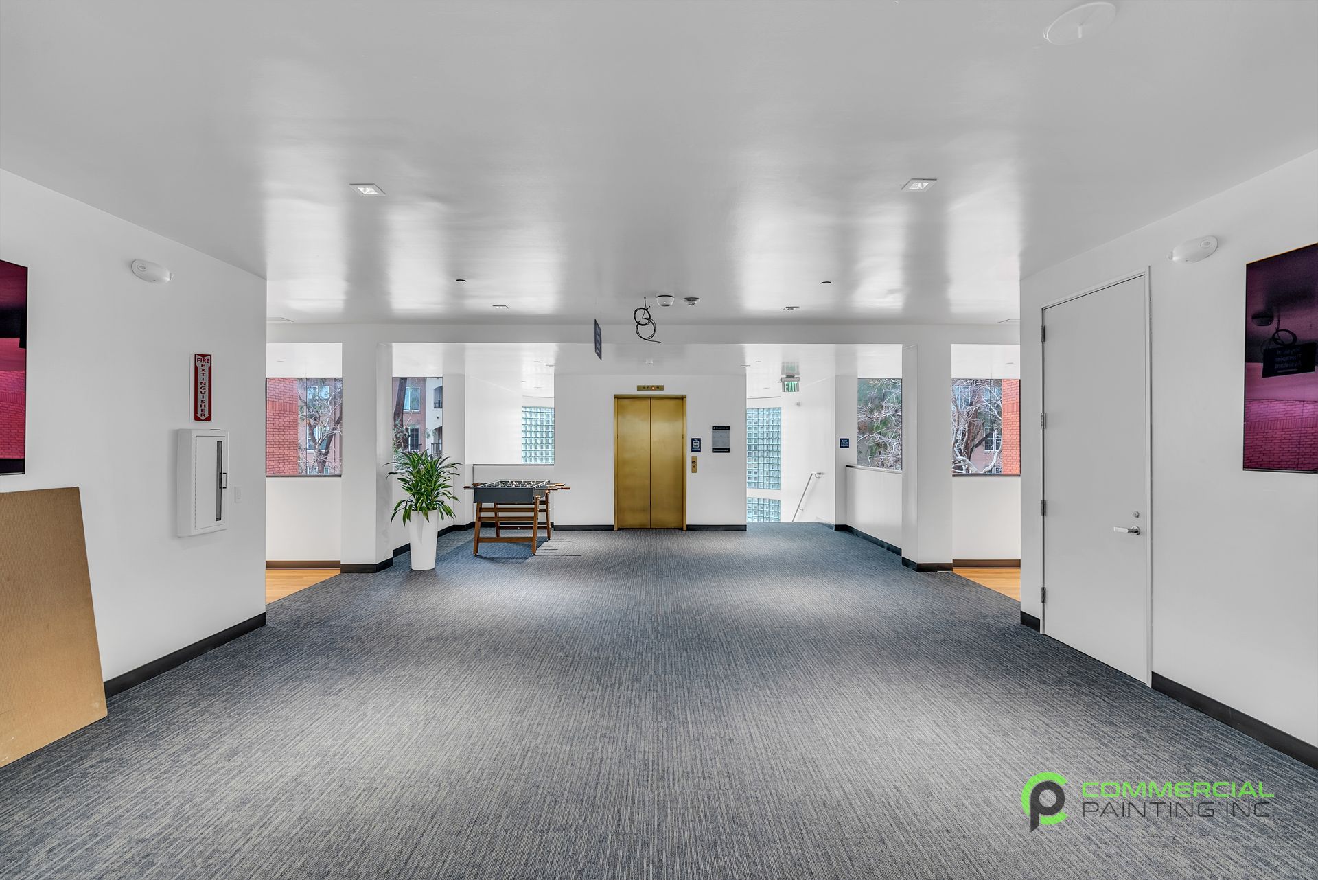 An empty hallway with a blue carpet and white walls