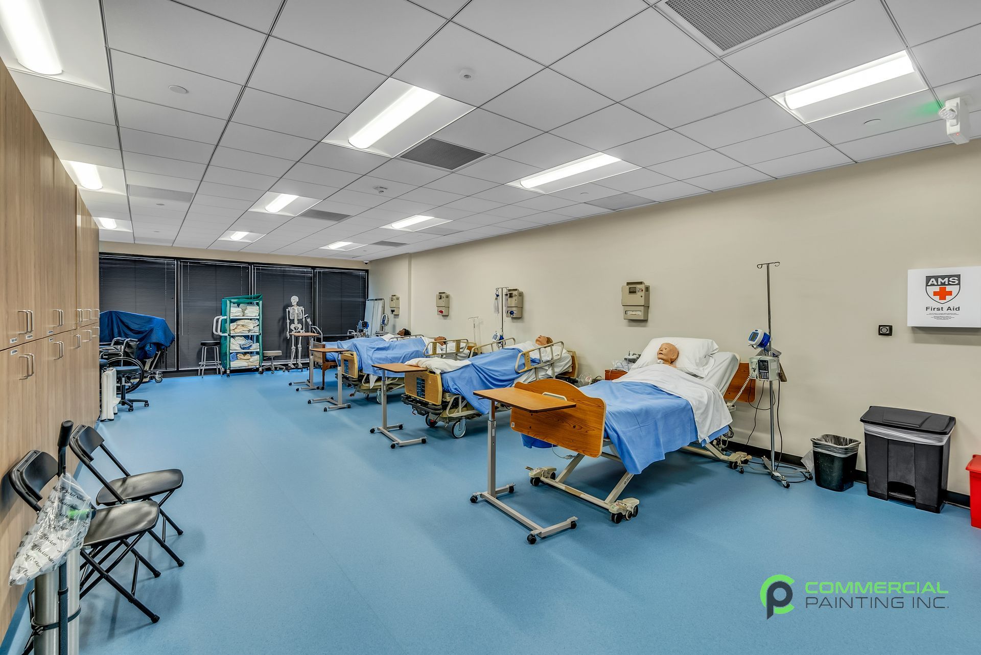 A large room with a lot of hospital beds and chairs.