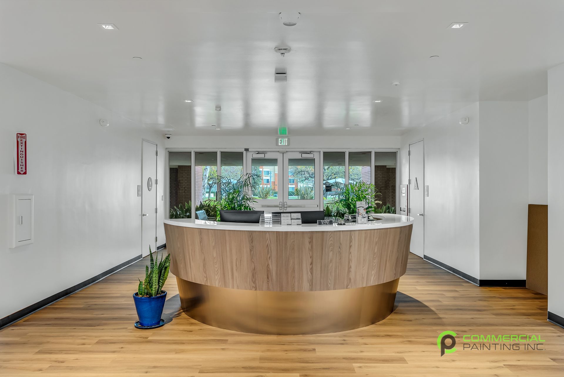 A reception area with a round wooden counter and a potted plant.