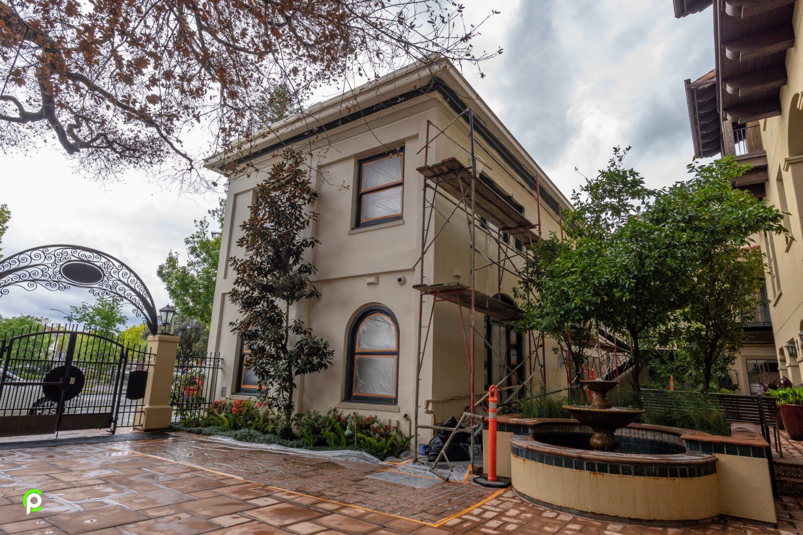 A large house with scaffolding around it is being painted.