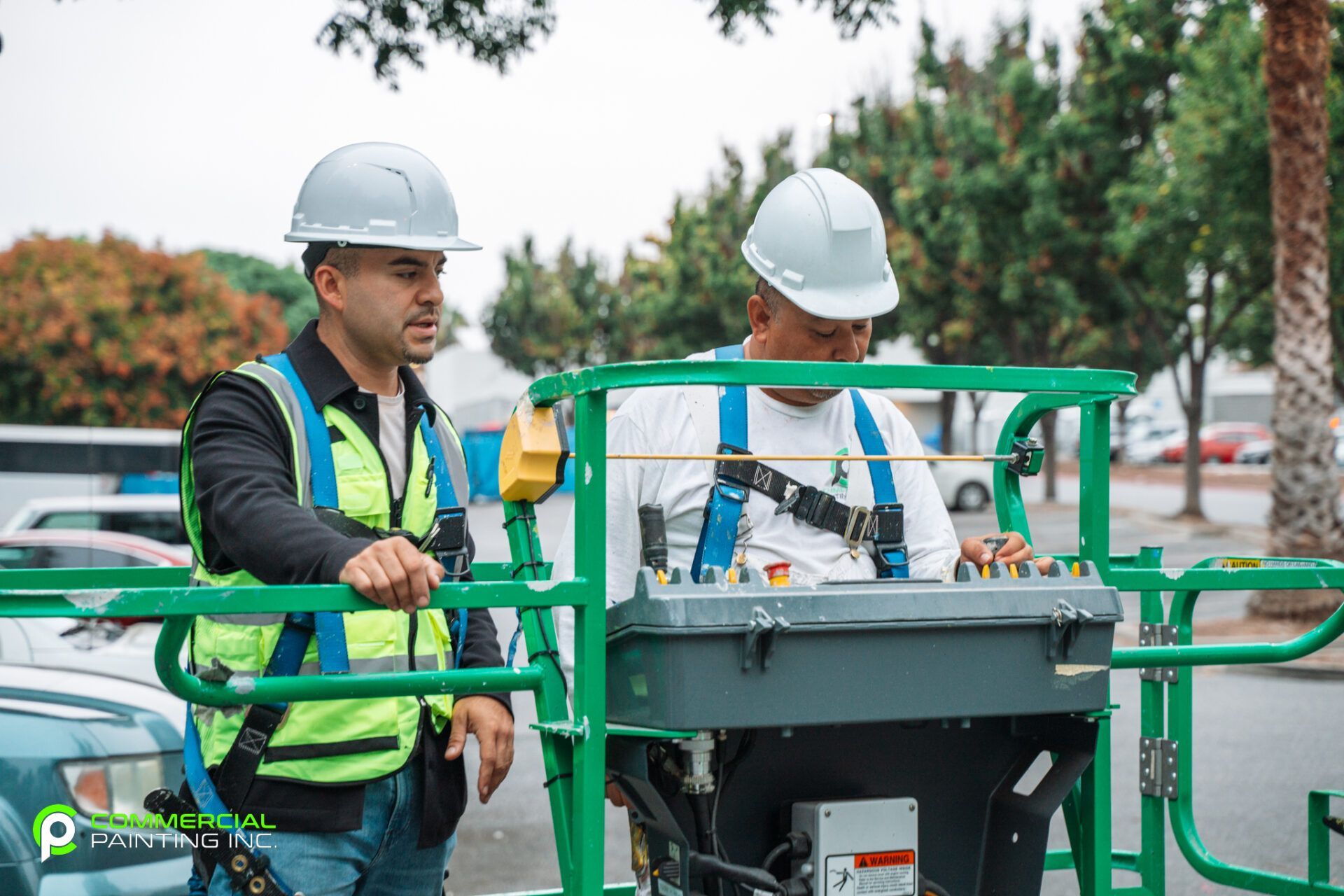 Two construction workers are standing next to each other in a parking lot.