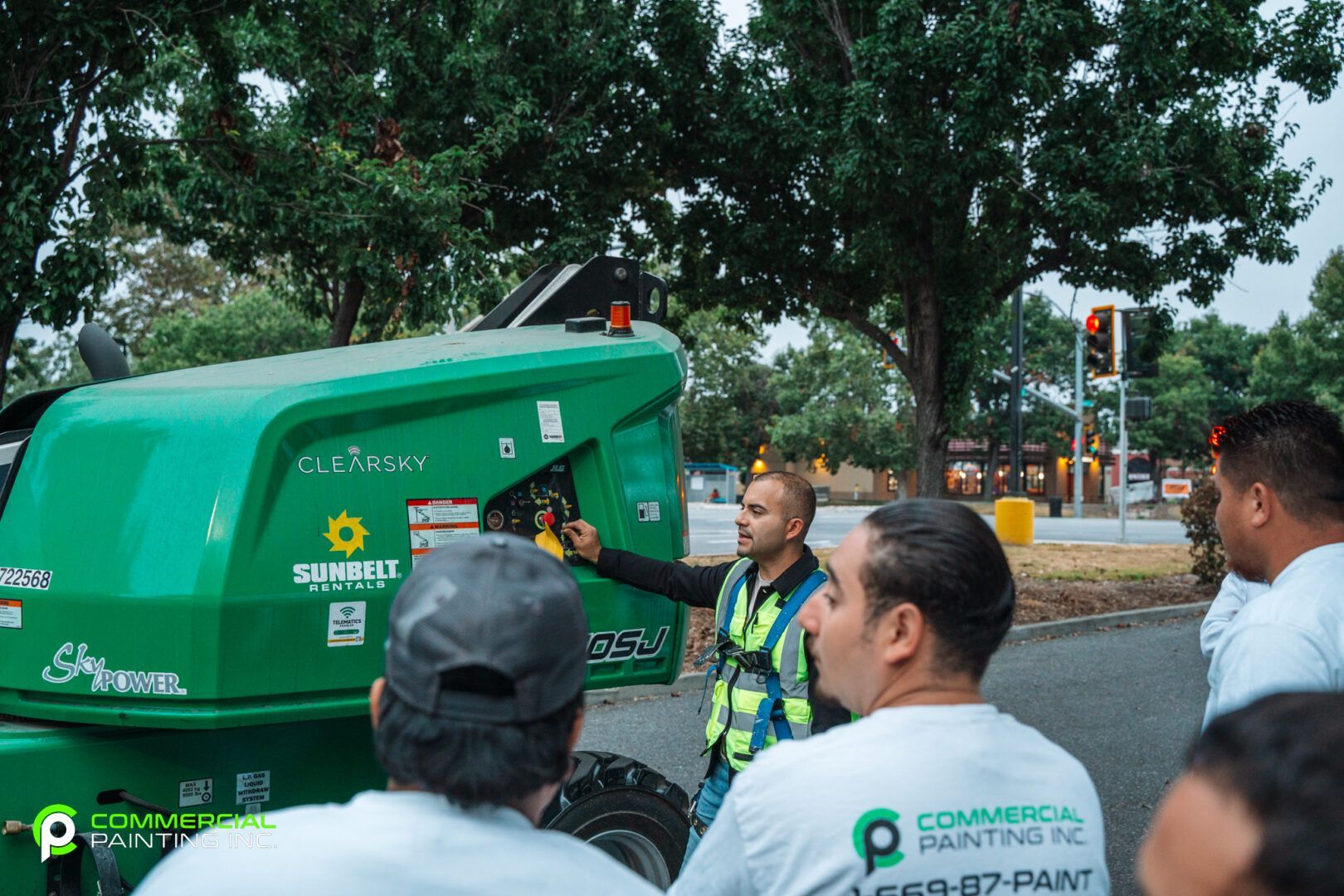 A group of men are standing around a green vehicle.