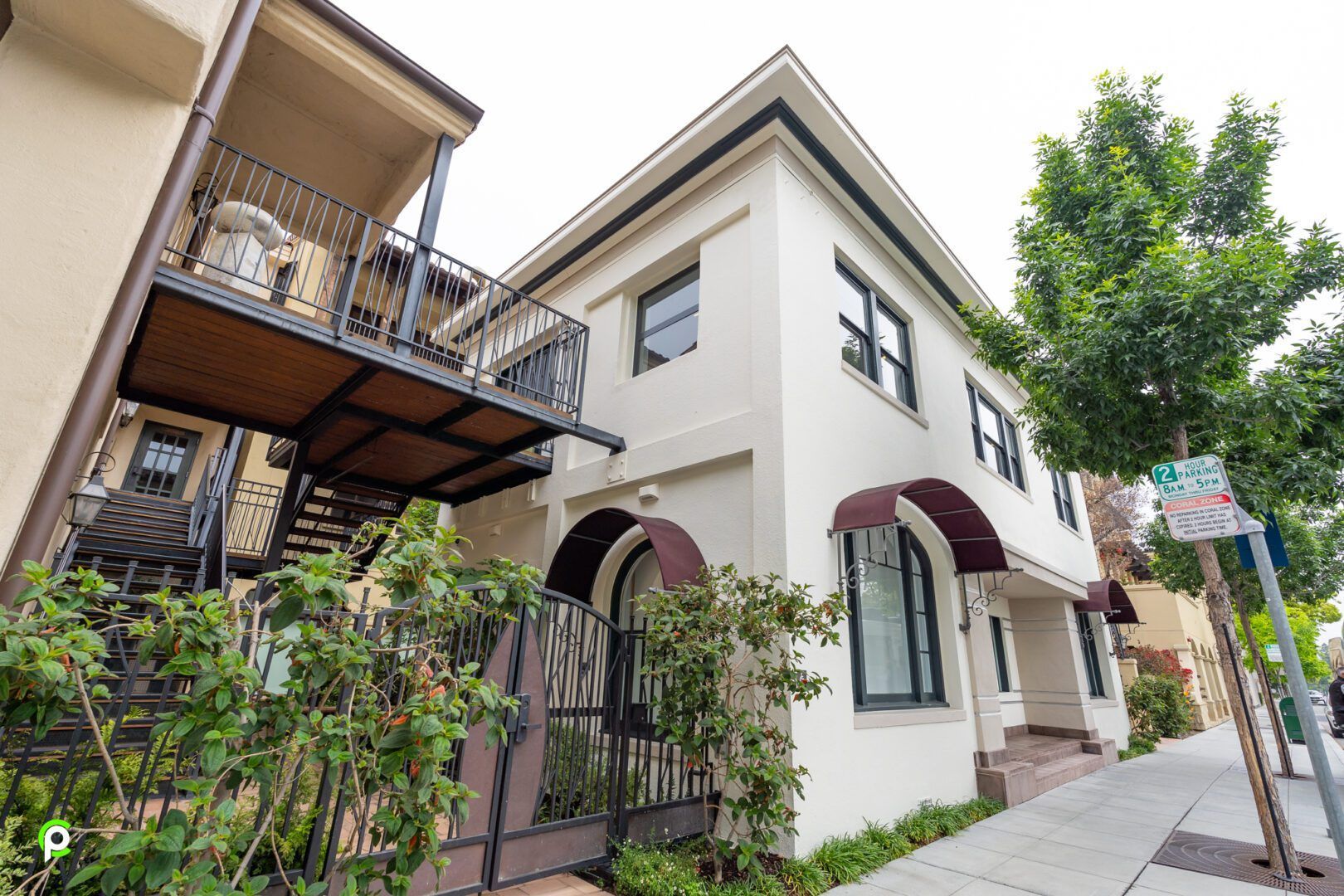 A large white building with stairs leading up to the second floor