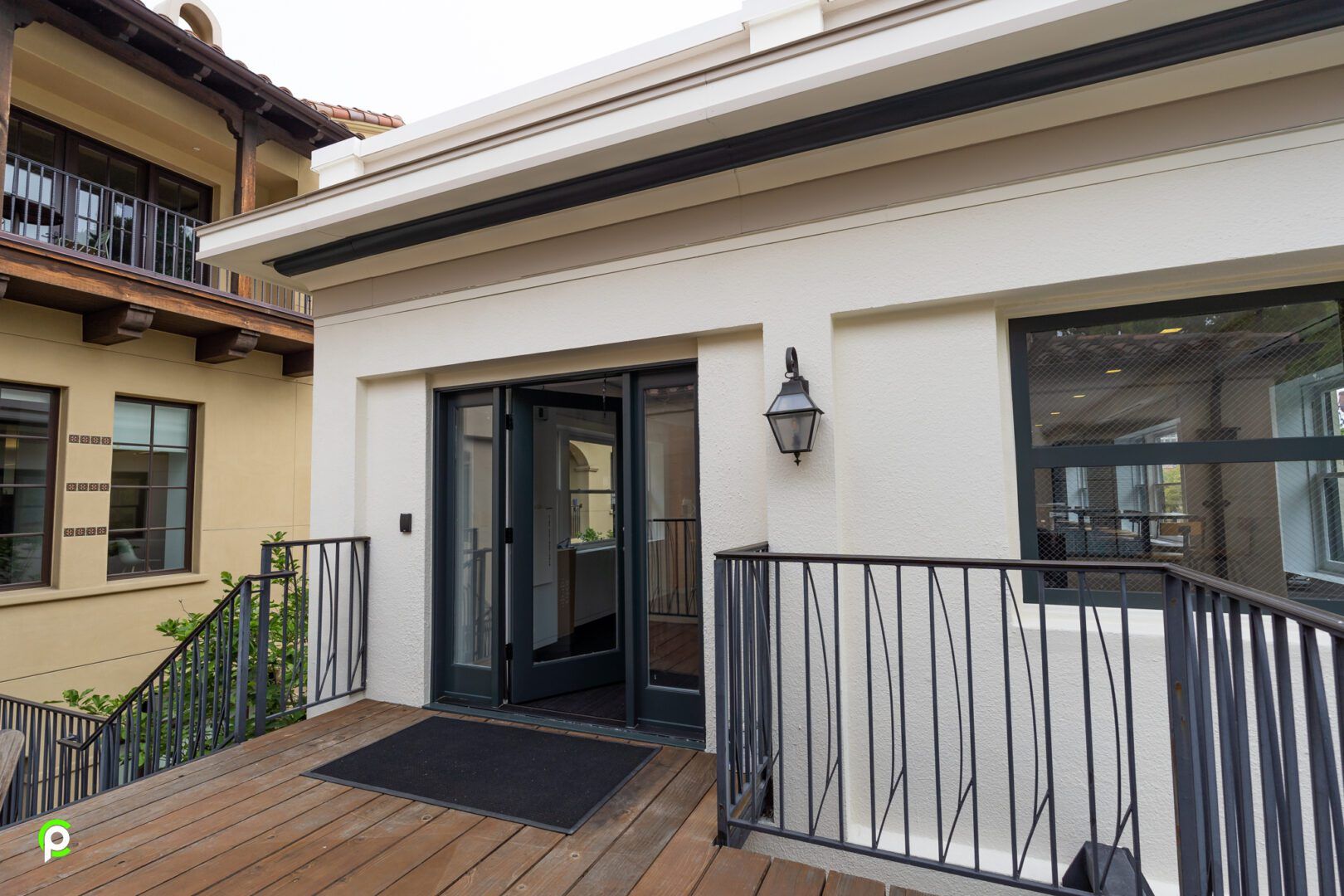 A white building with a balcony and stairs leading to it.