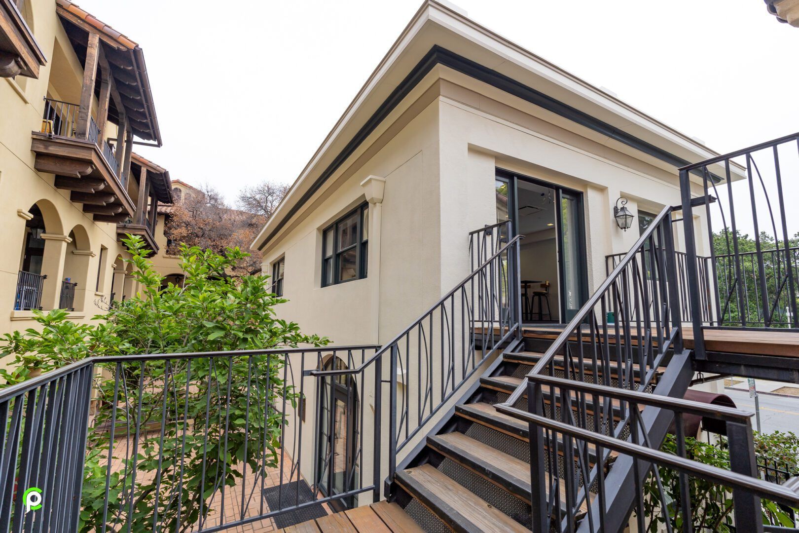 A house with stairs leading up to it and a balcony.