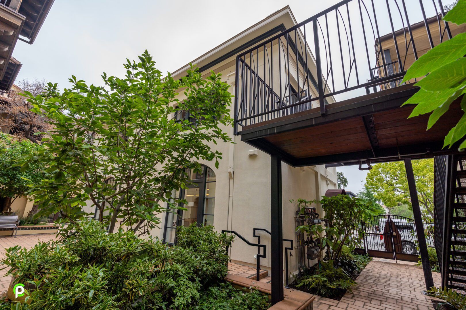 A white house with a balcony and stairs leading to it.