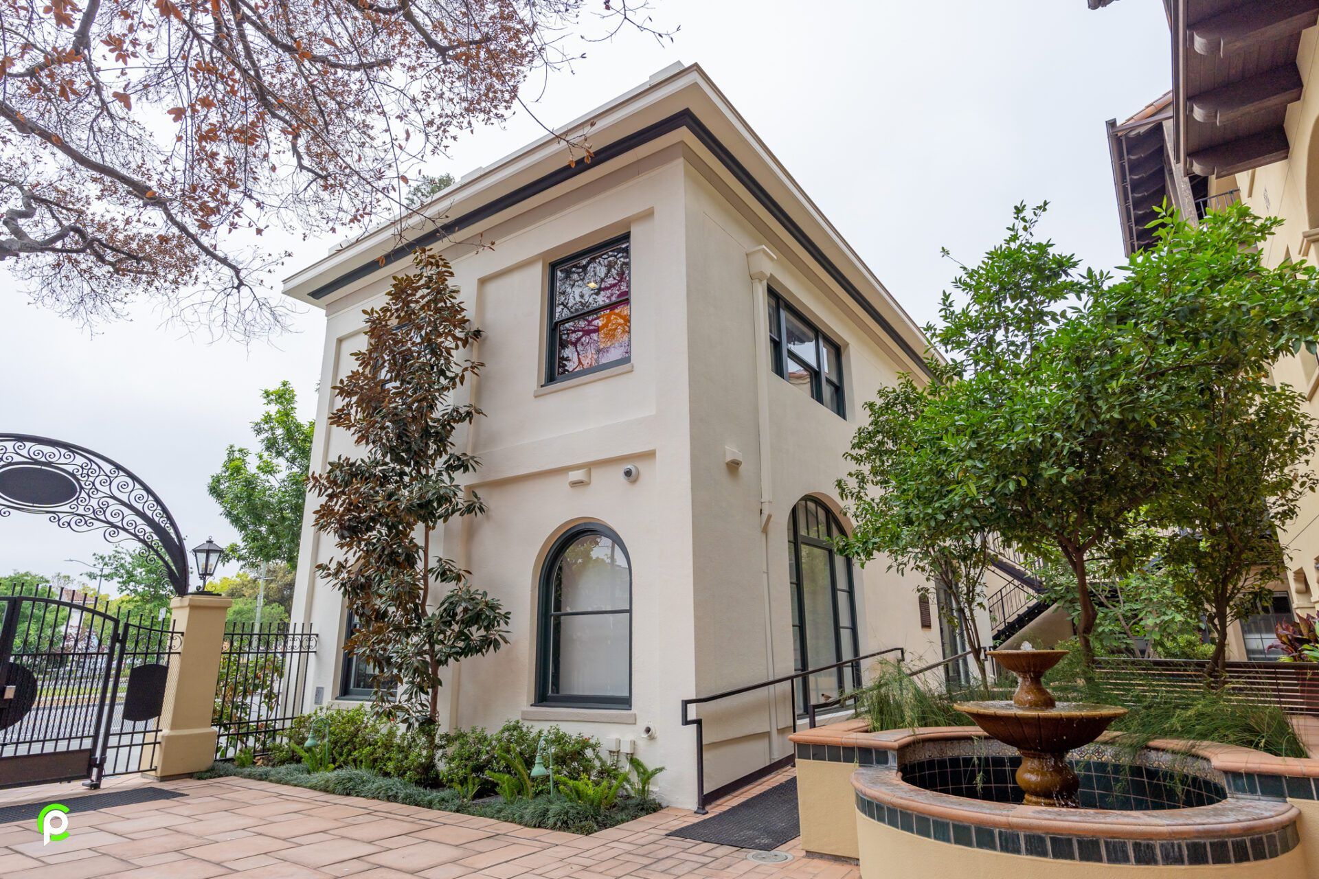 A large white house with a fountain in front of it