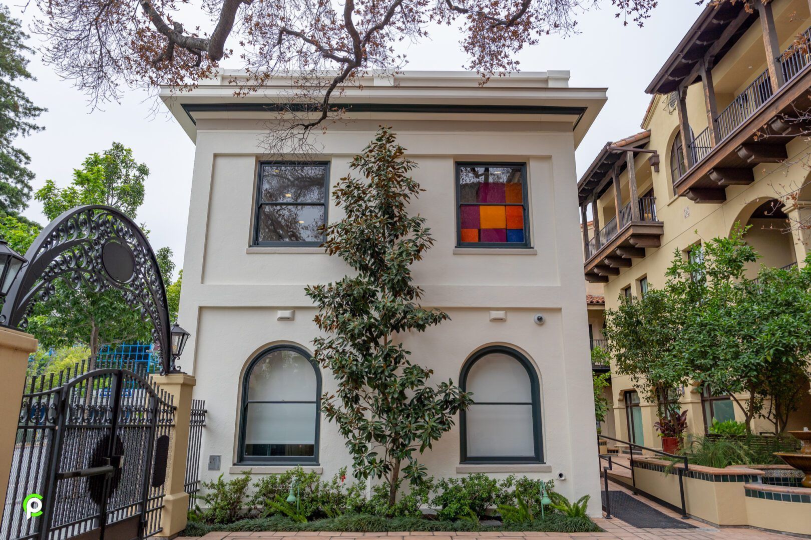 A white house with arched windows and a stained glass window