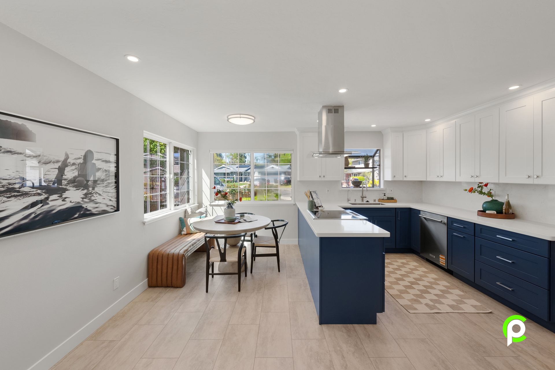 Modern kitchen with blue cabinets, white countertops, and a dining area.