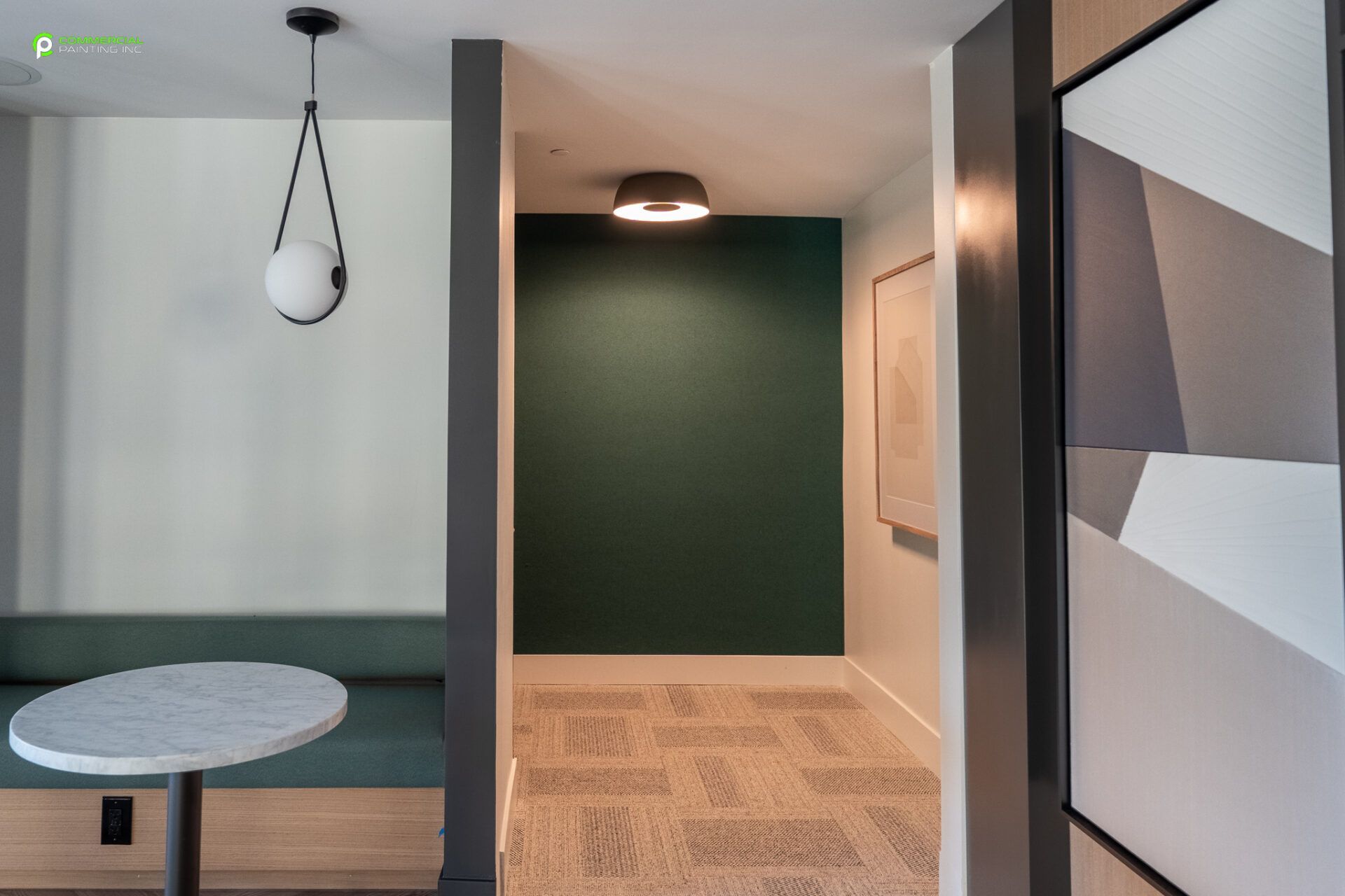 A hallway with a table and a painting on the wall.