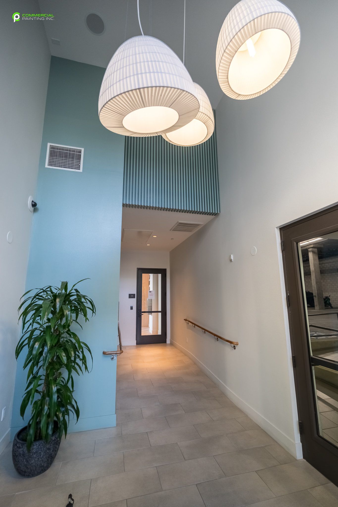 A hallway with a potted plant and hanging lights