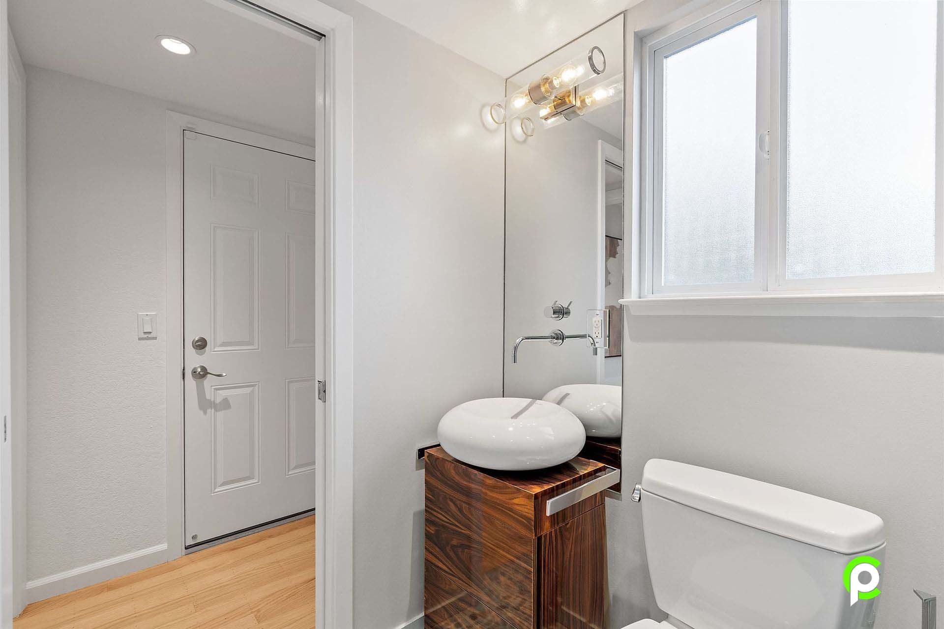 A bathroom with a sink , toilet and mirror.