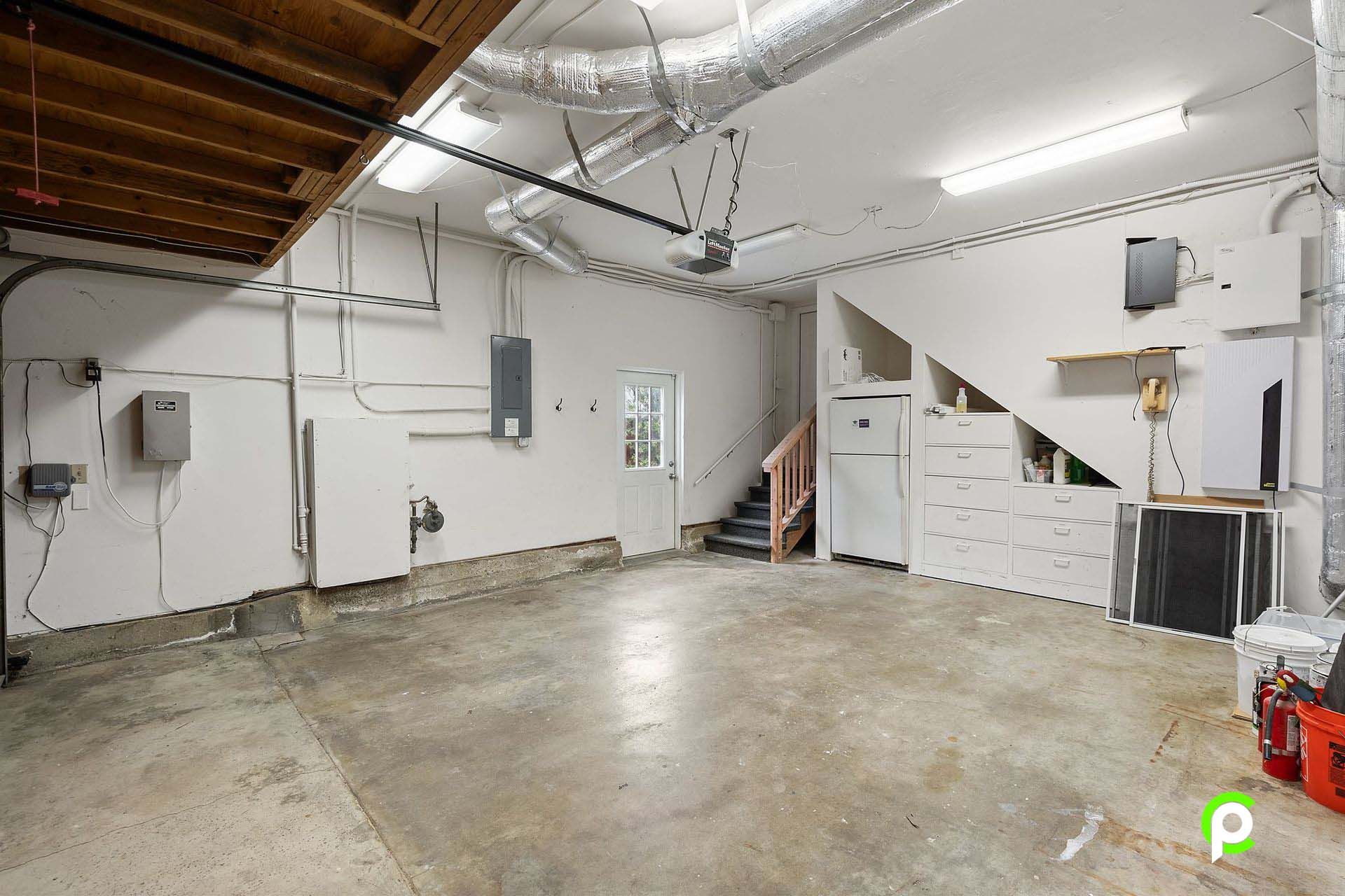 An empty garage with white walls and a concrete floor.