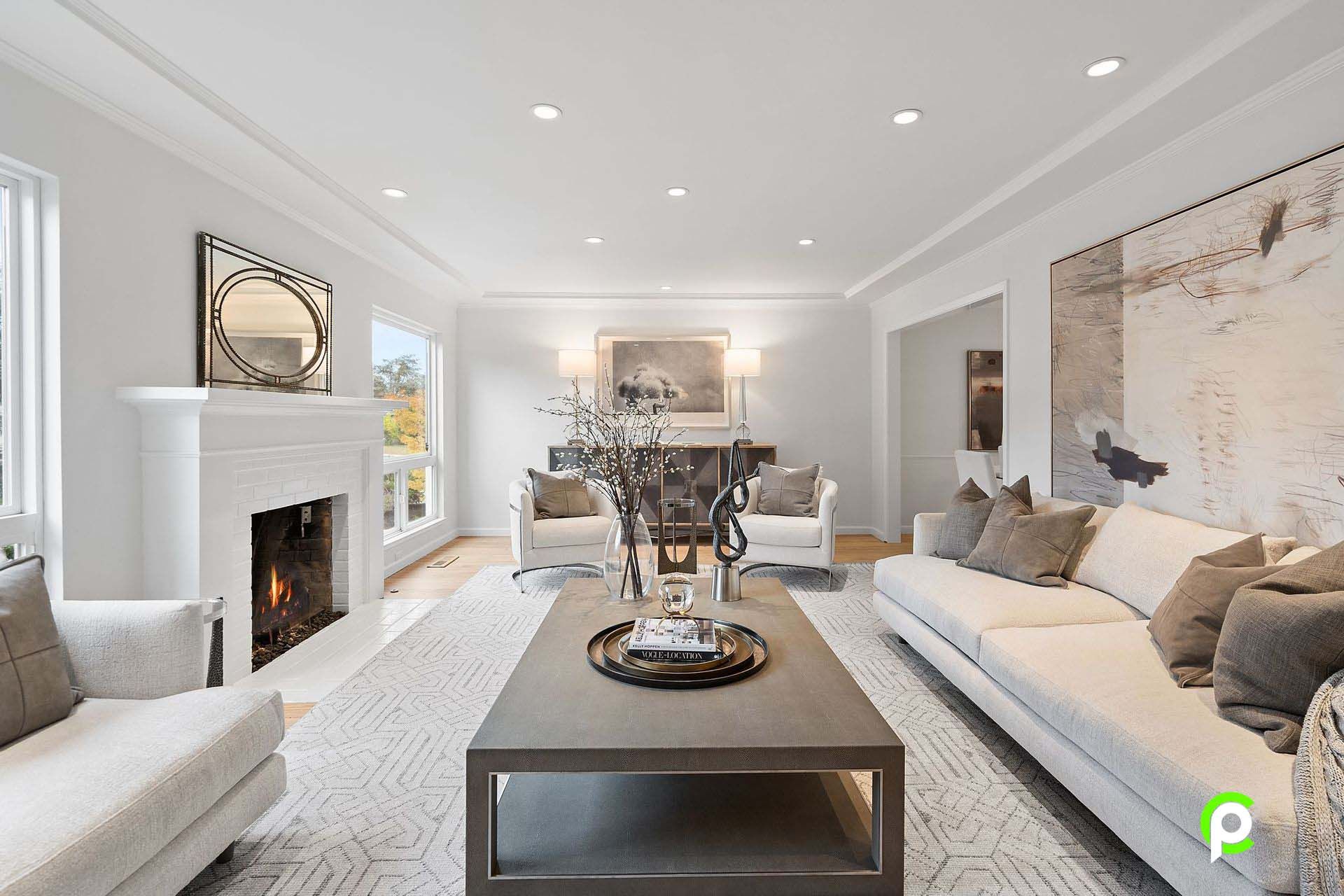 A living room with a couch , chairs , coffee table and fireplace.