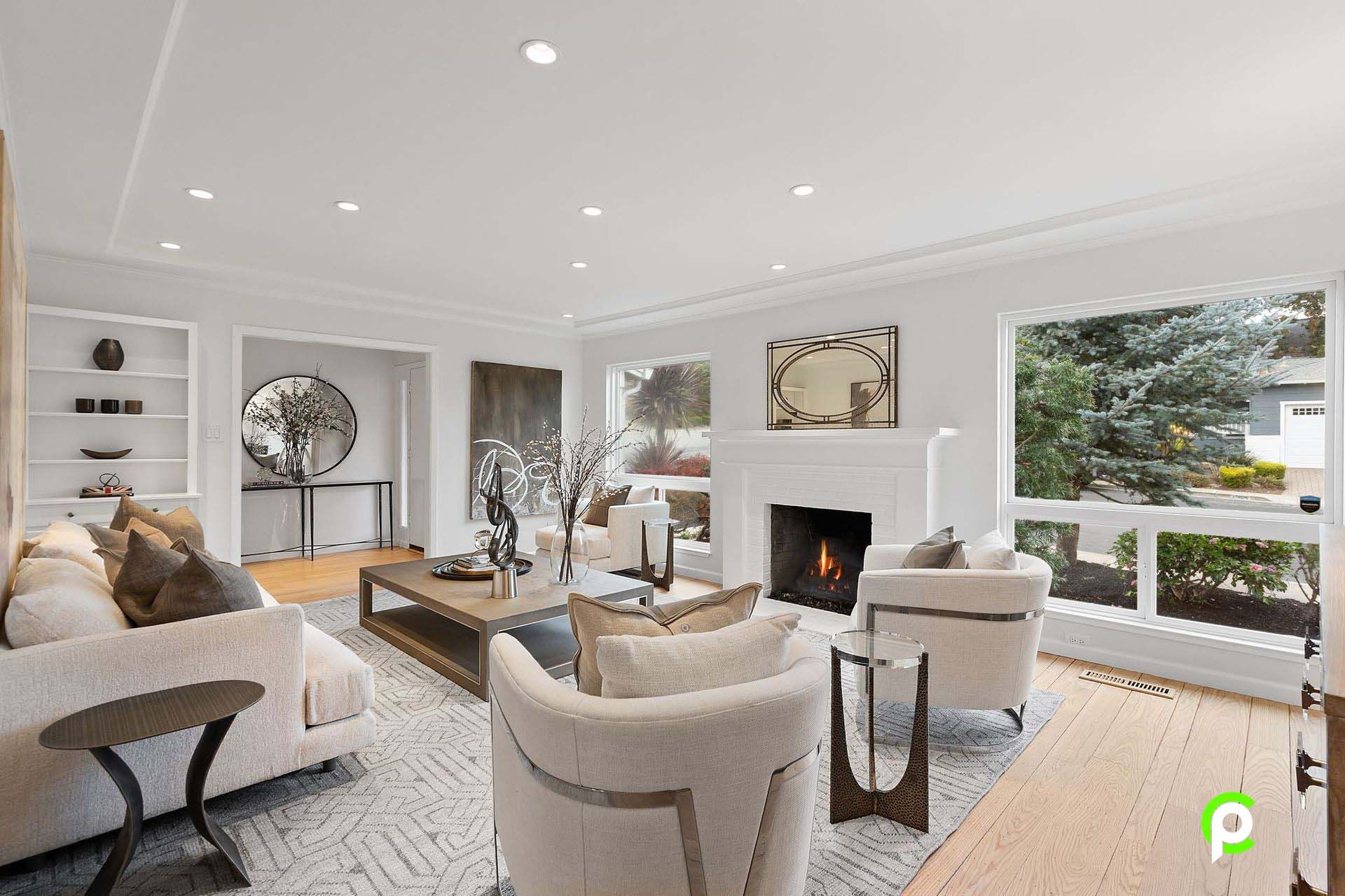 A living room with a couch , chairs , coffee table and fireplace.