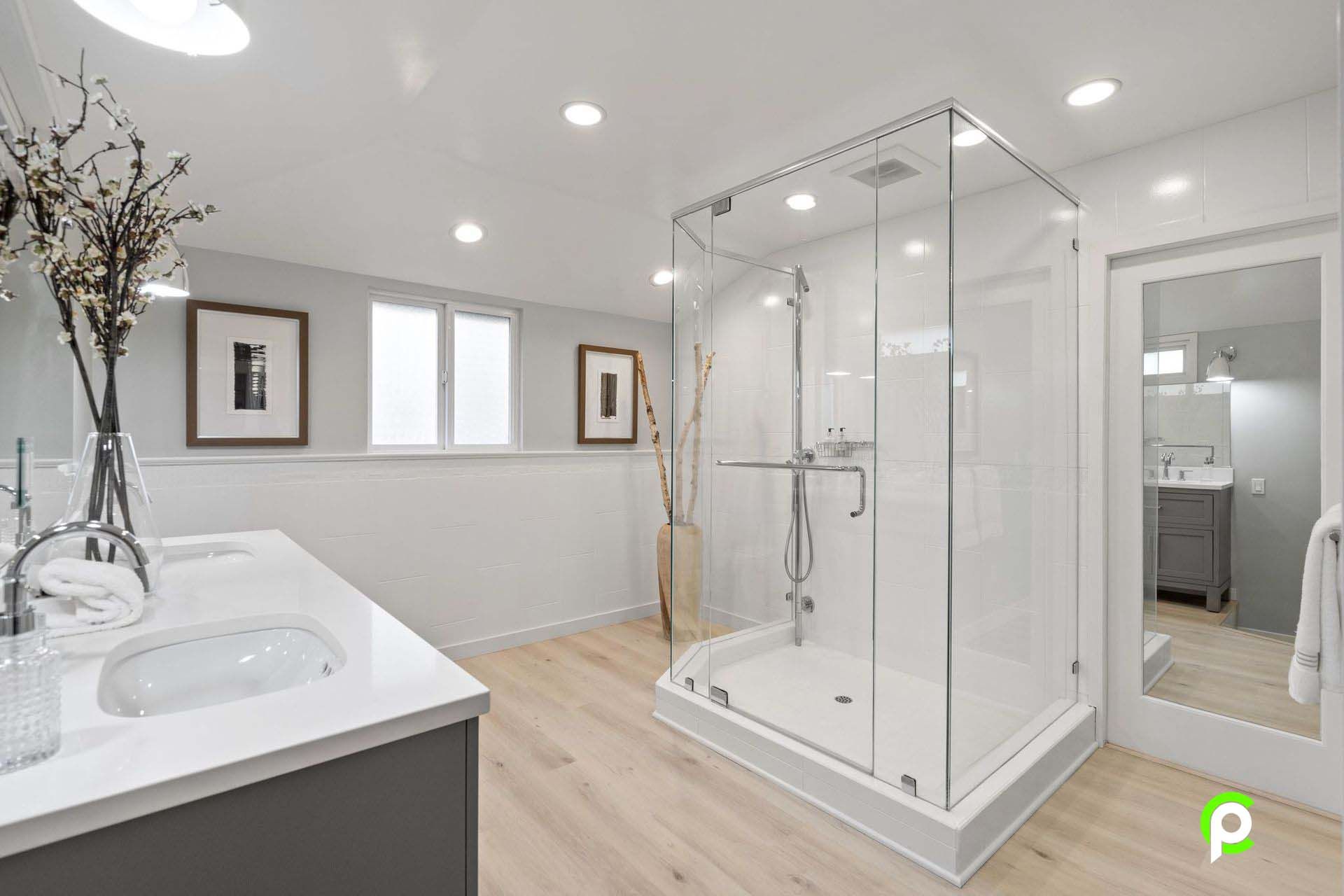 A bathroom with a walk in shower and a sink.