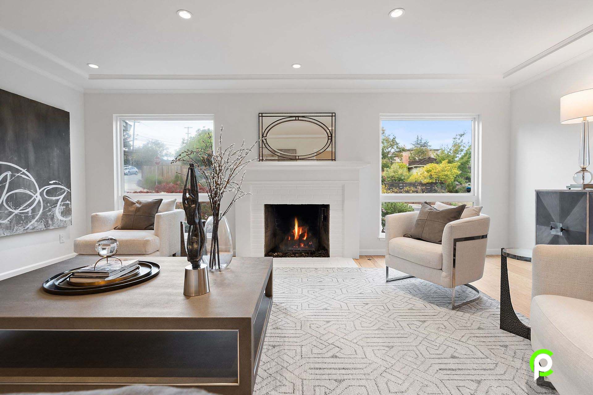 A living room with a fireplace , chairs , and a coffee table.