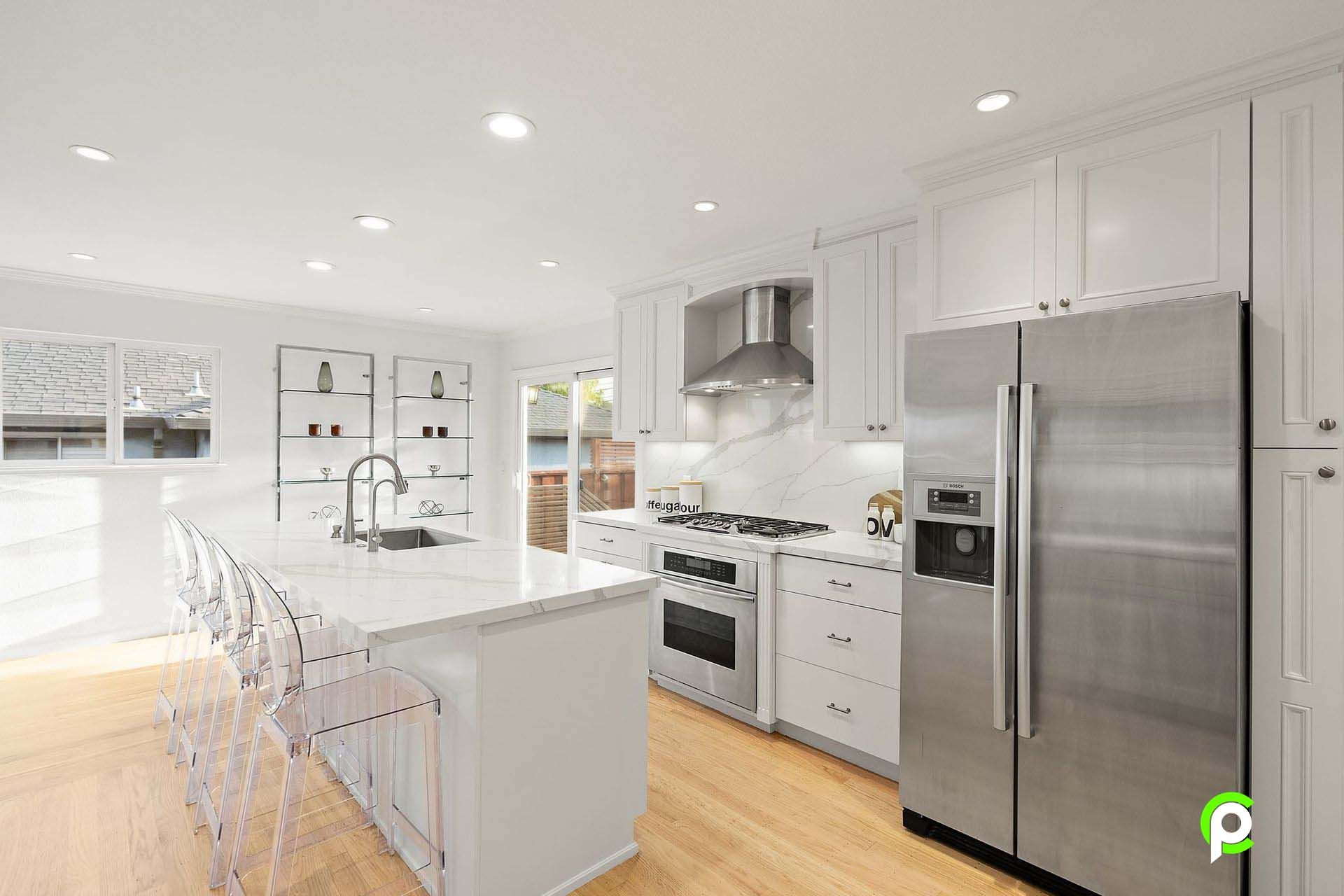 A kitchen with white cabinets and stainless steel appliances.
