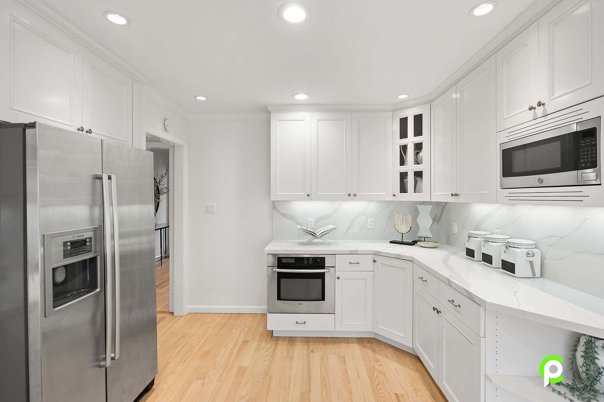 A kitchen with white cabinets and stainless steel appliances.