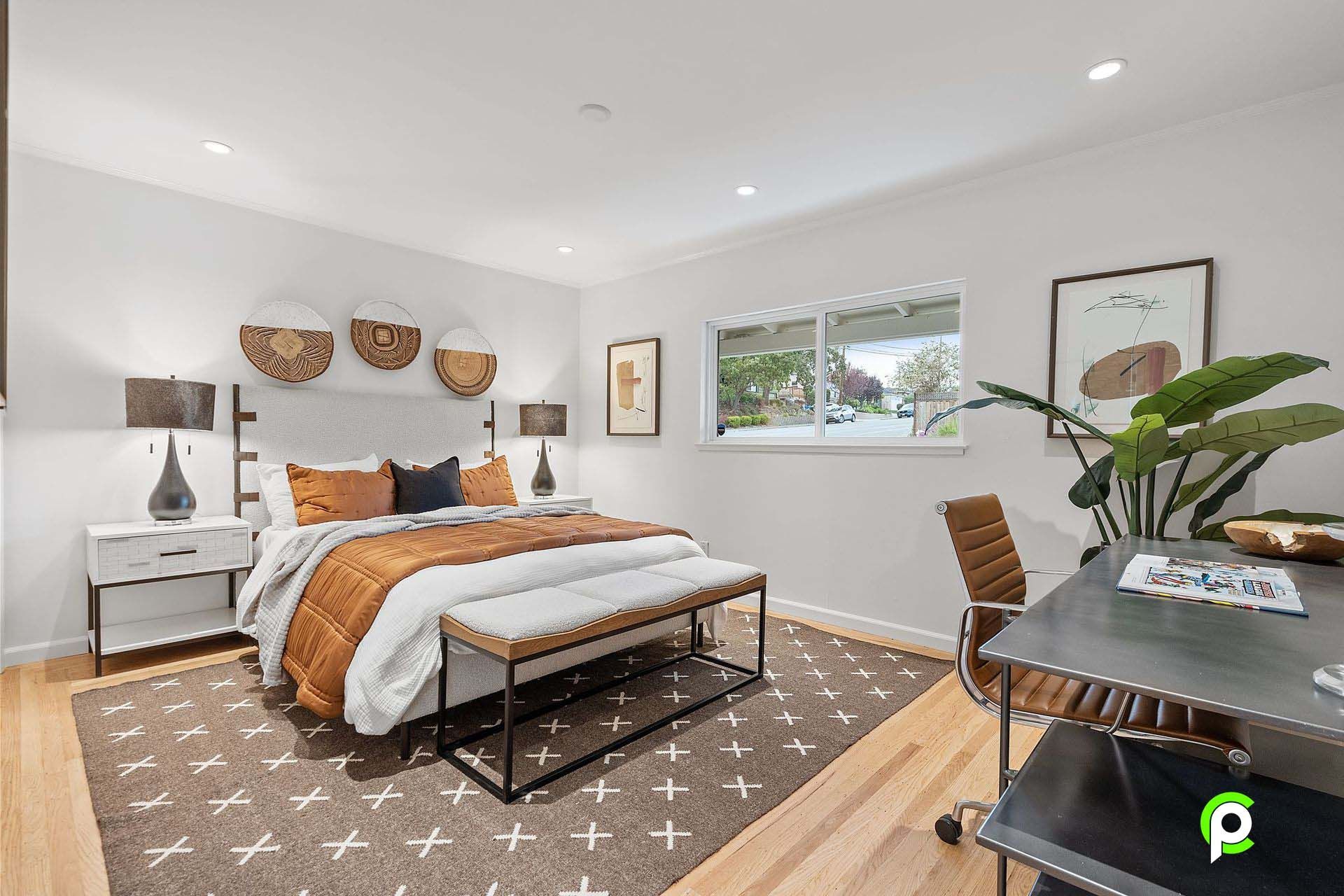 A bedroom with a bed , desk , chair and rug.