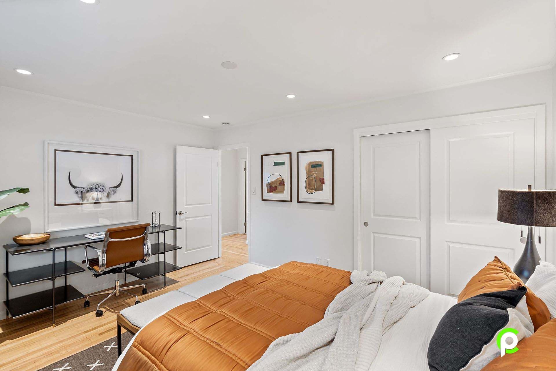 A bedroom with a large bed , desk and chair.